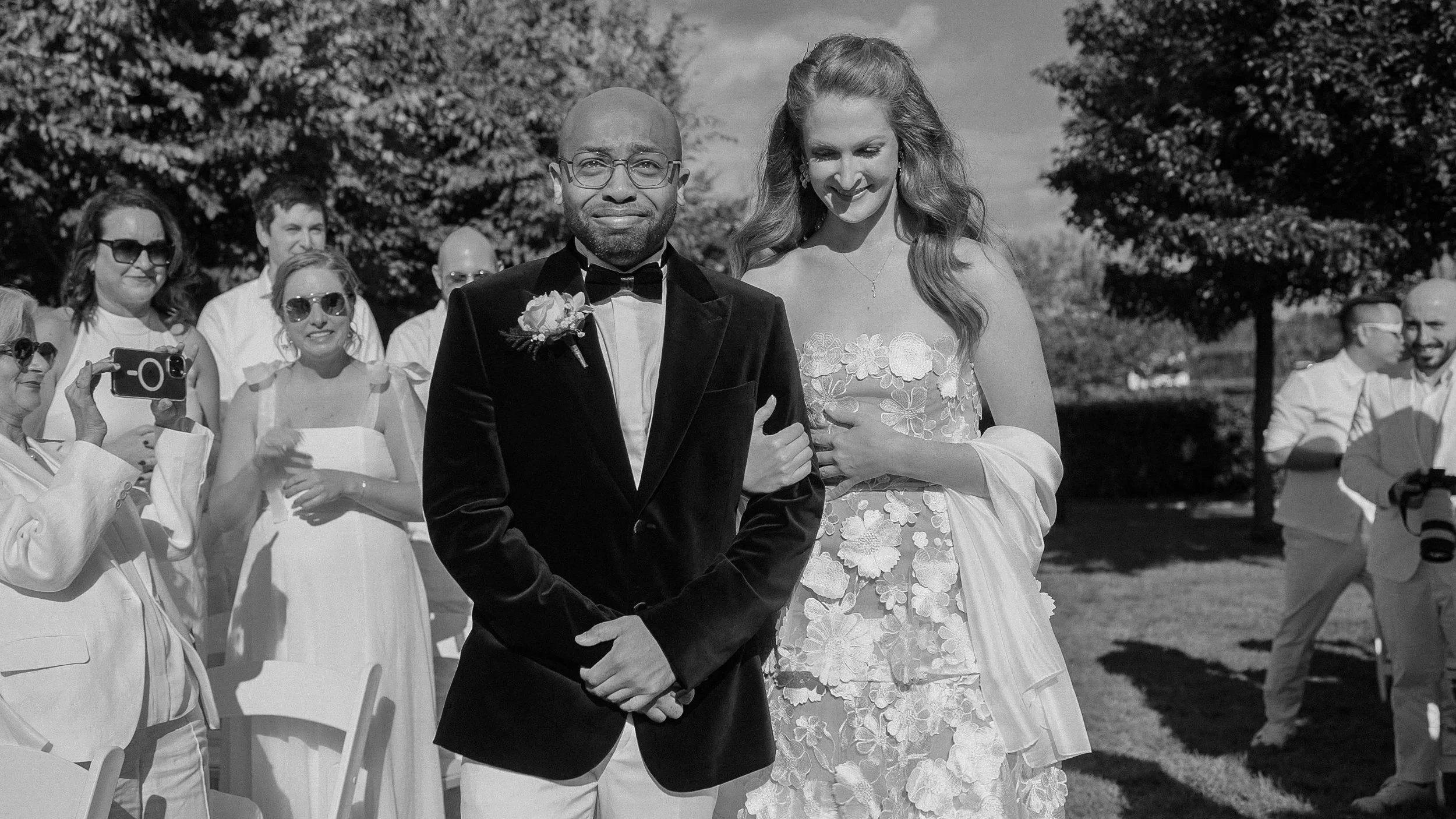 Black and white photo of a groom walking down the aisle at an outdoor Darver Castle wedding ceremony, Co. Louth