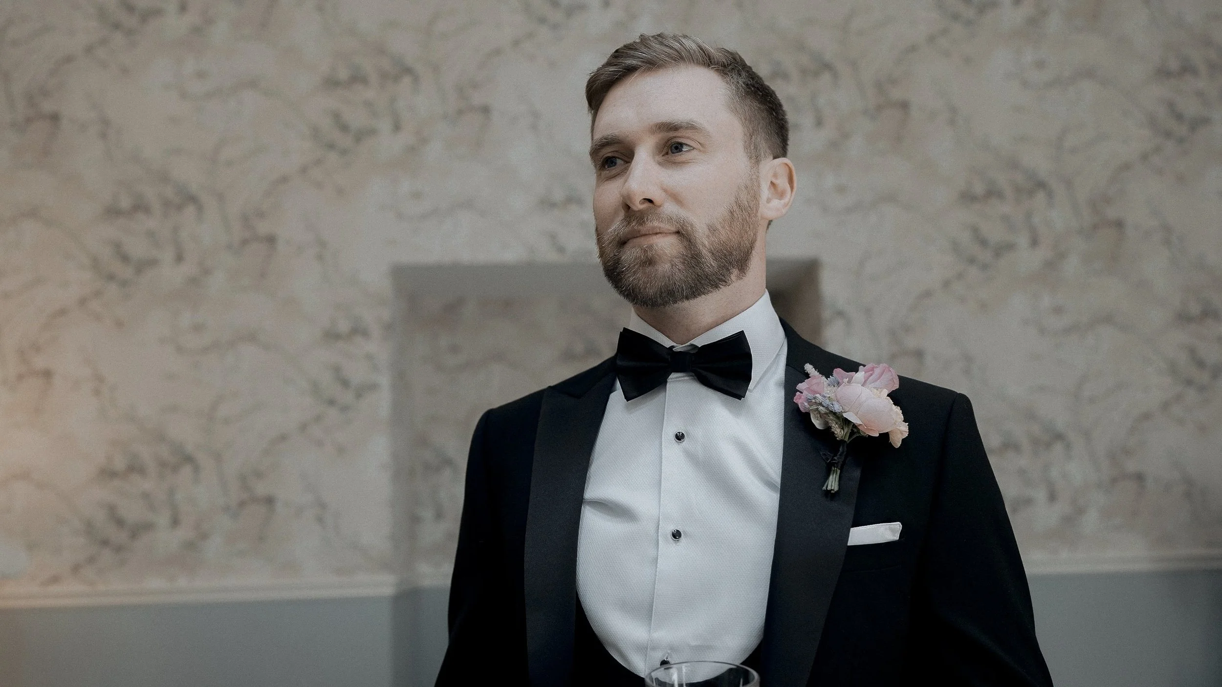 Groom in a black tuxedo with a pink rose buttonhole at Tinakilly Country House