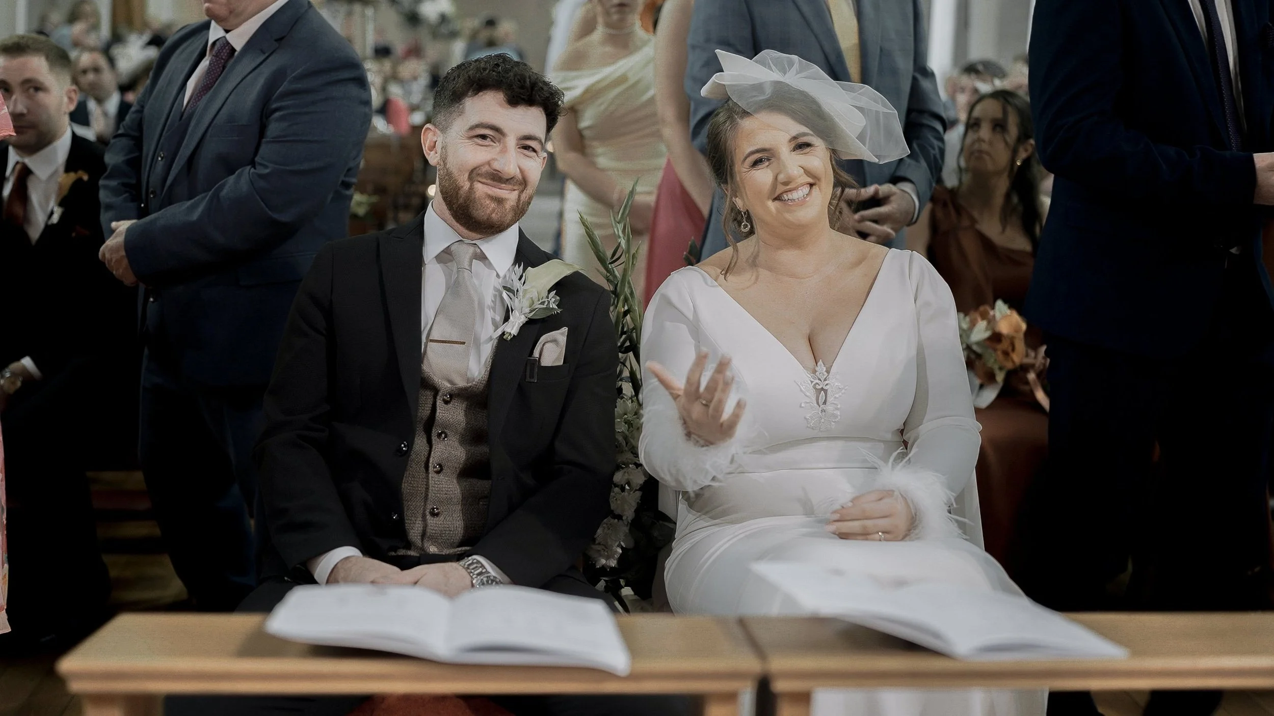 Smiling bride and groom seated at the altar during their ceremony at Christ the King Church, Cooleragh, Co. Kildare