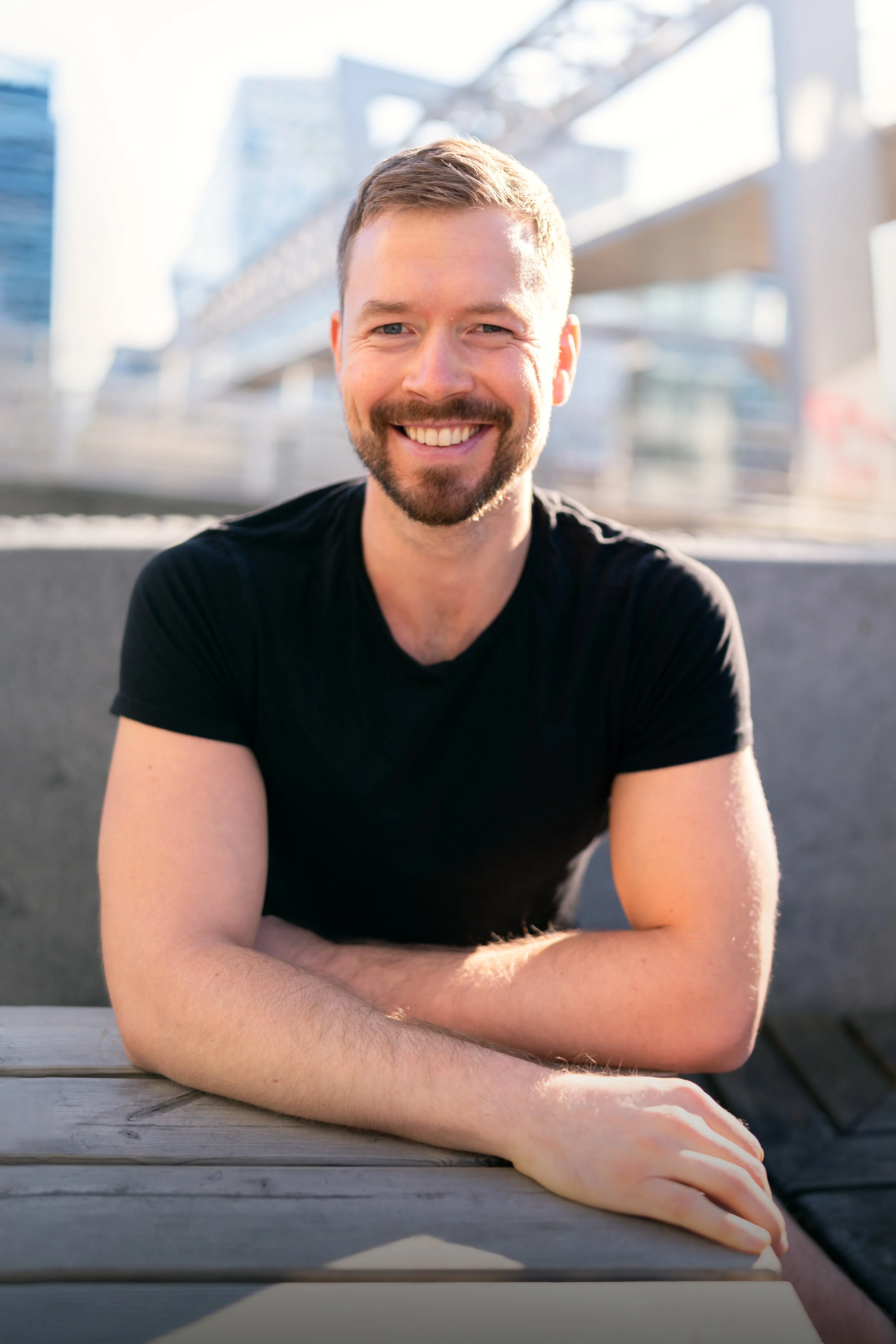 man smiling at the camera in a black t-shirt