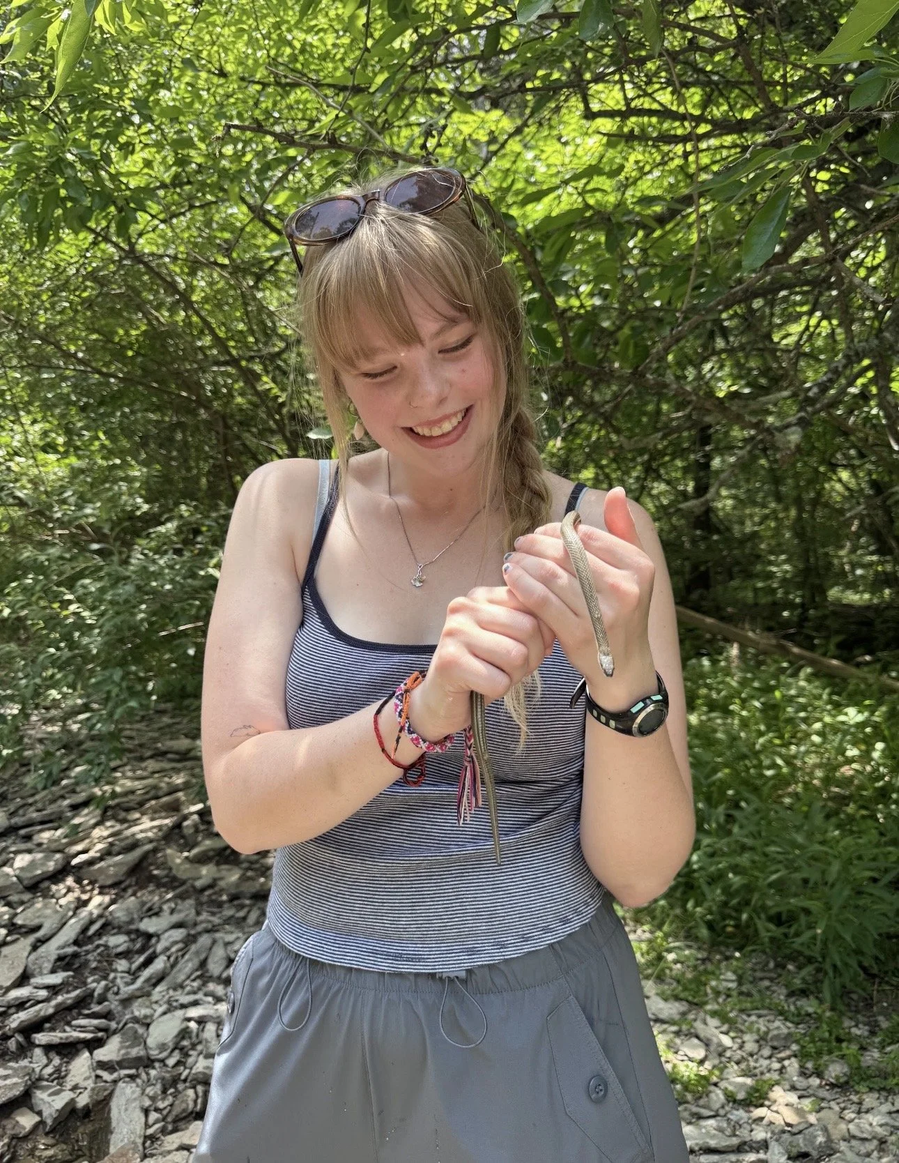 An image of Trinity smiling and holding a snake