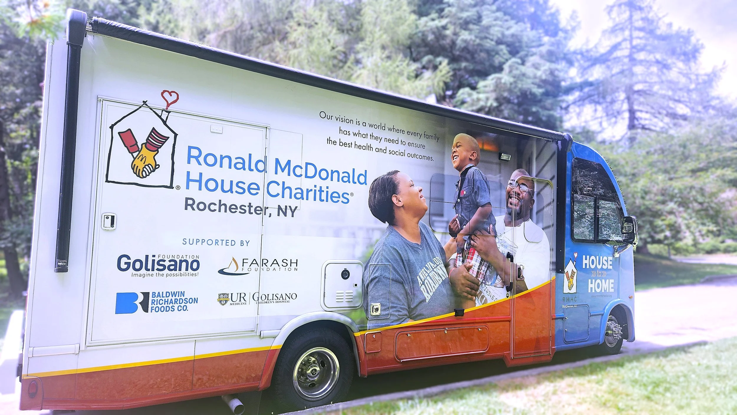 A large mobile vehicle with gorgeous graphics identifying is as Ronald McDonald House of Rochester, New York's House to Home vehicle.