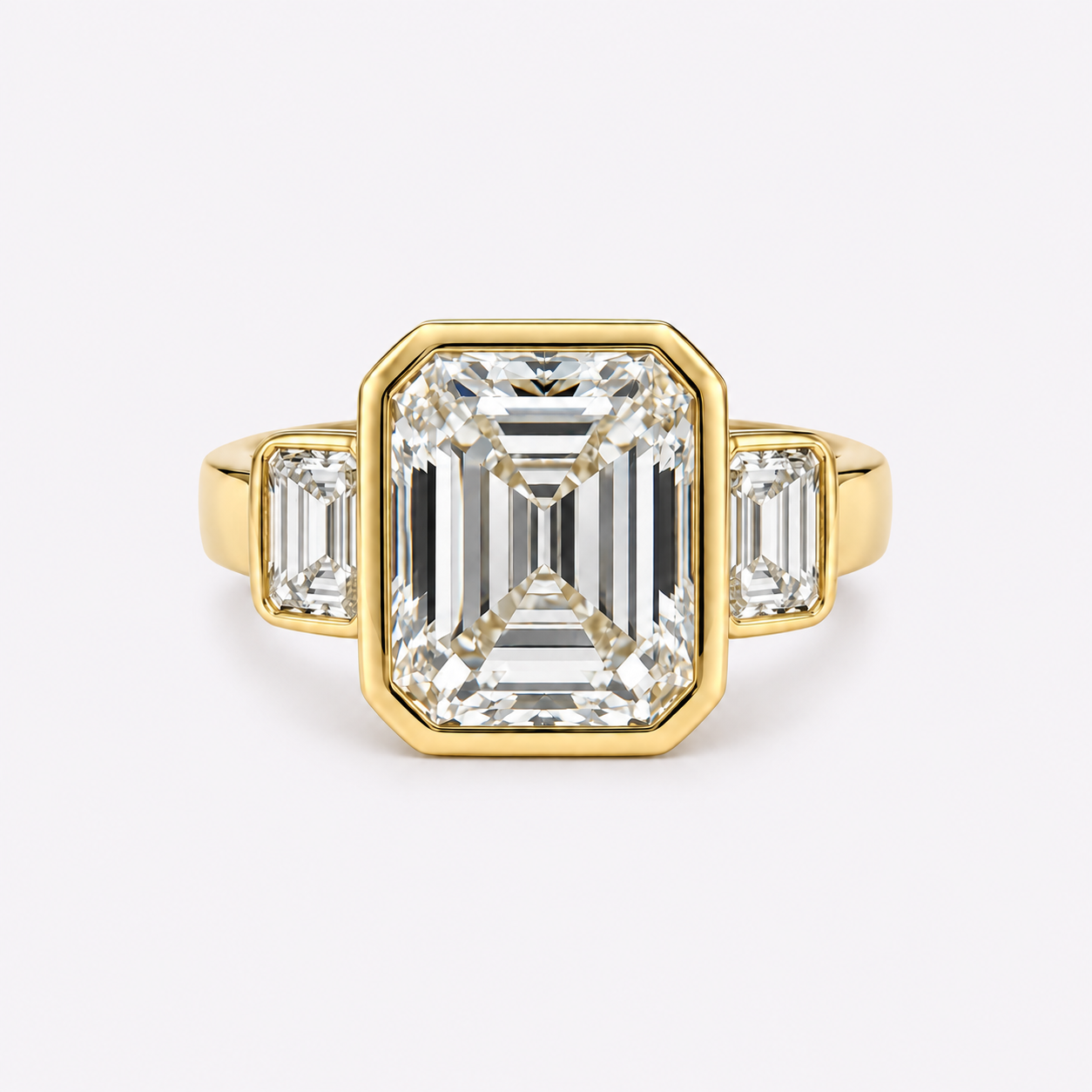 Gold ring with three large emerald-cut diamonds, one central and two smaller side stones, on a white background.