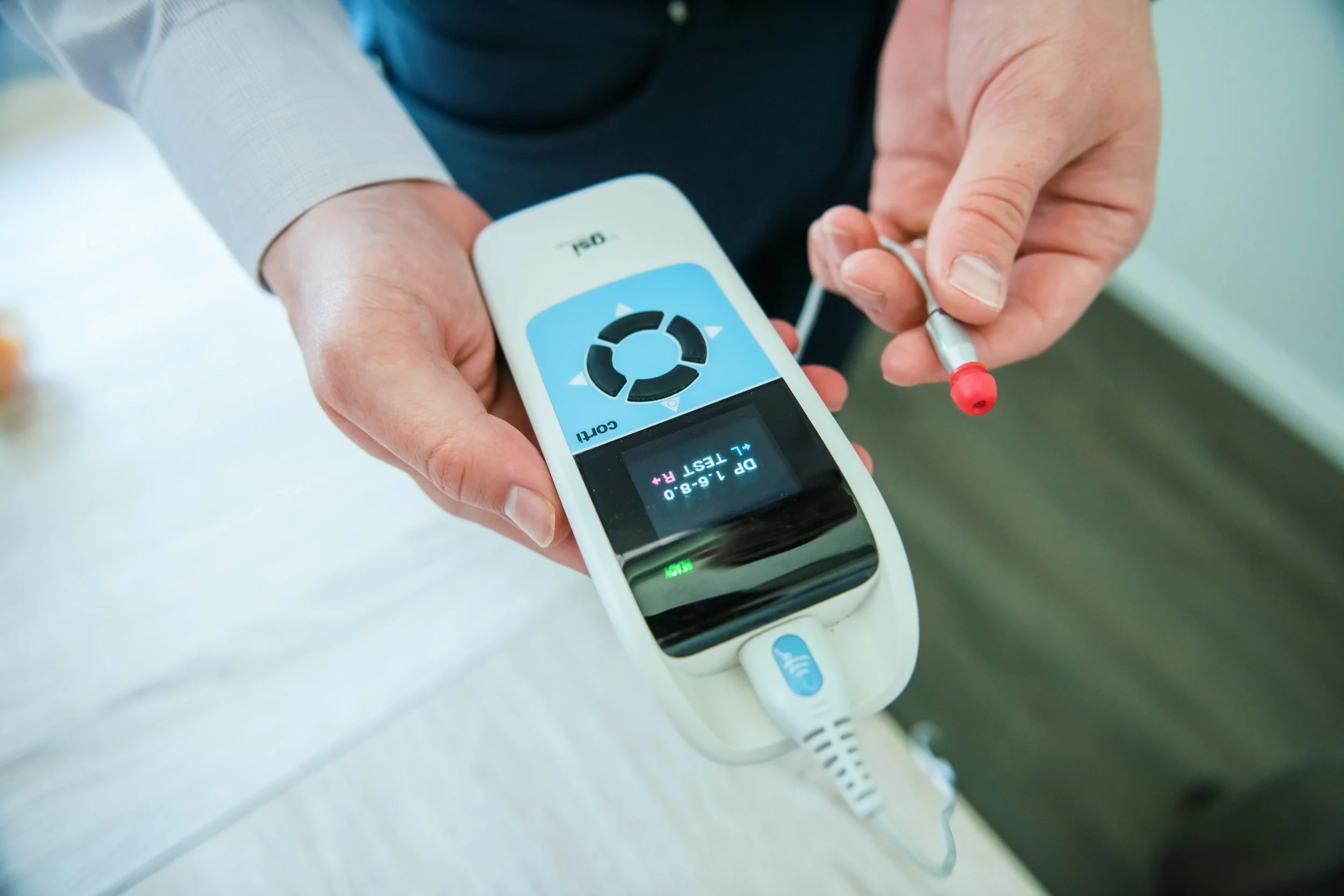 The Audiologist is performing OAE (otoacoustic emissions) testing on a child to determine the patient's cochlear function.