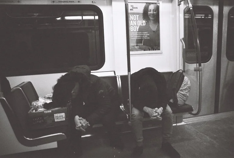 Two guys tired riding the subway