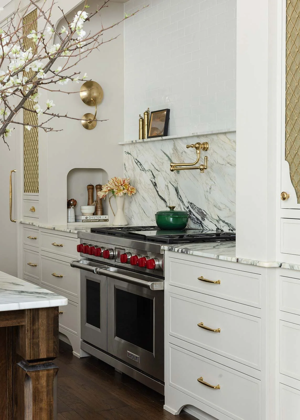 Indian Springs AL kitchen renovation highlighting a luxury stainless steel Wolf range and matching heavily-veined marble slab backsplash.