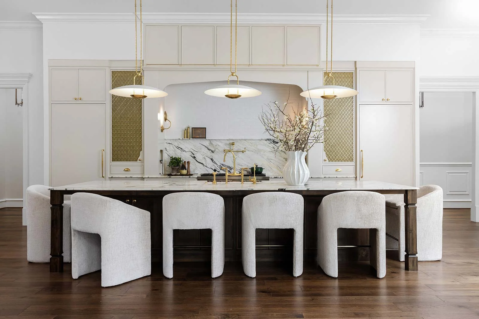 Luxury kitchen remodeling in Indian Springs Alabama featuring a large dark wood island with marble countertops and custom arched range hood.
