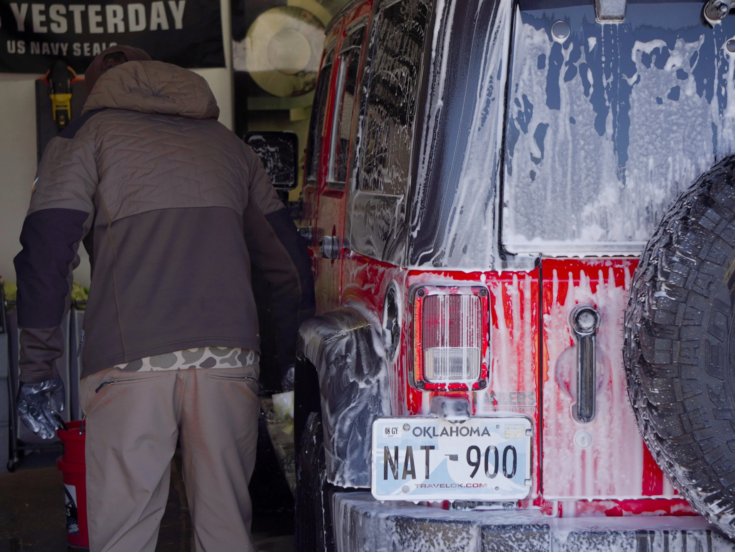 Hand washing a red jeep
