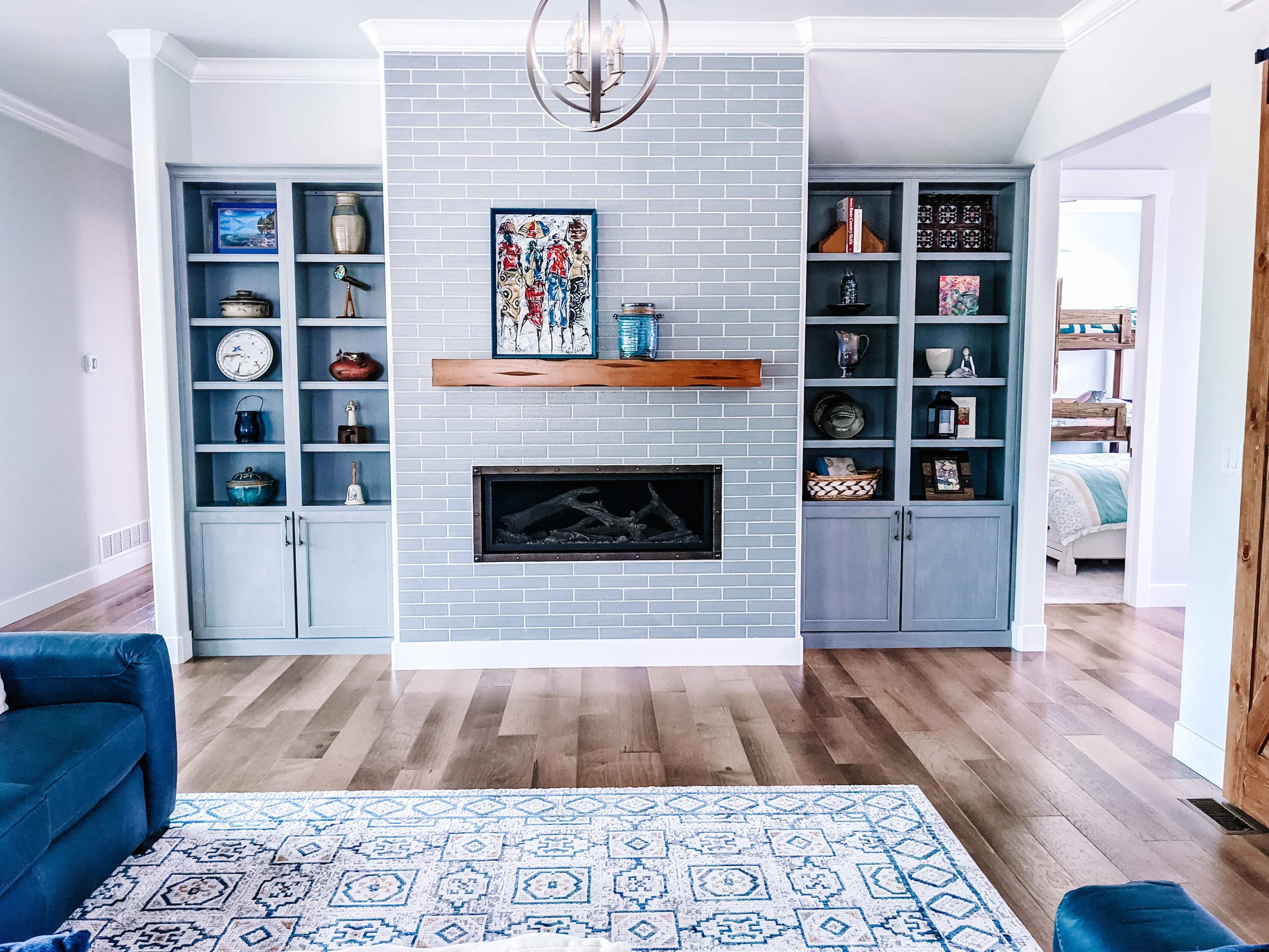 Modern farmhouse interior with tiled fireplace and built in bookcases.