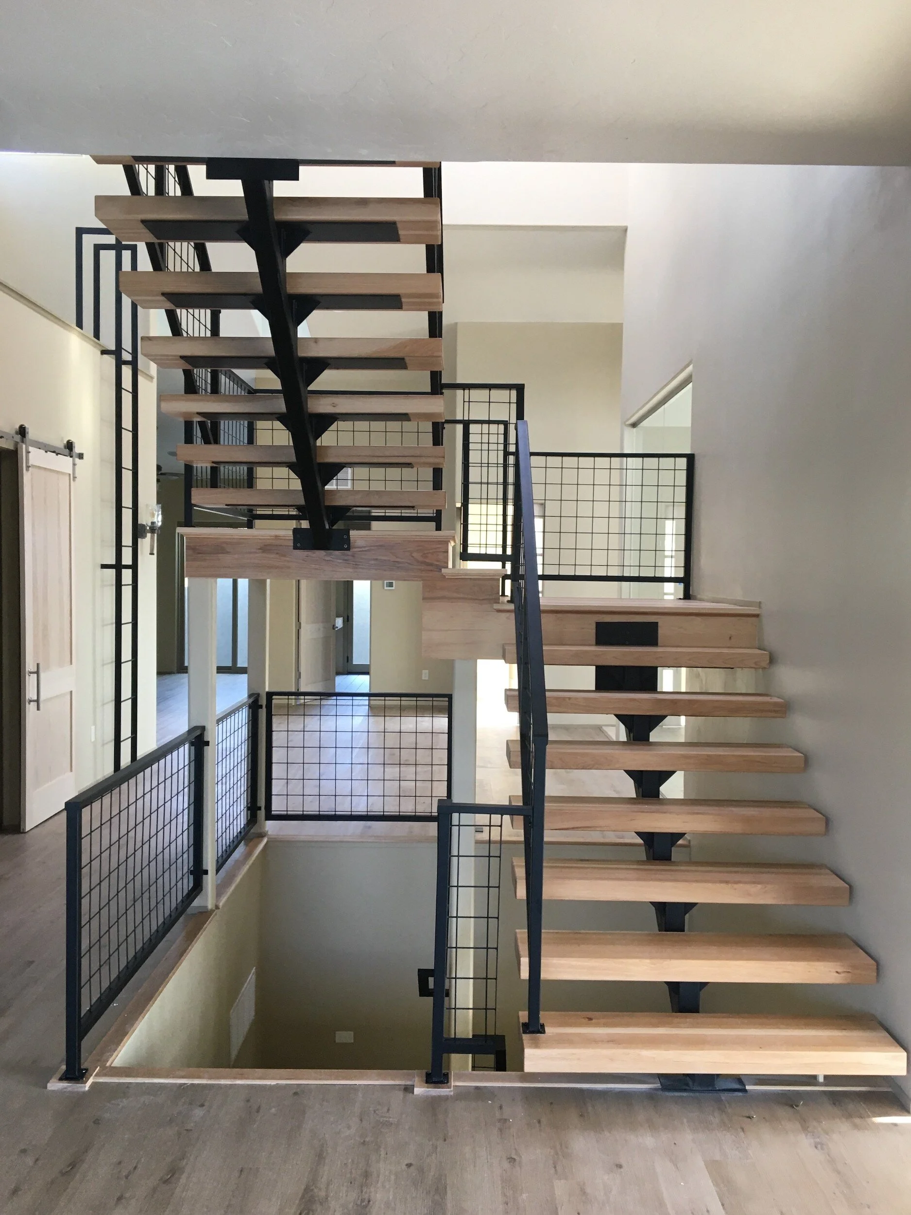 Modern staircase with contemporary wooden steps and metal railings in a custom Colorado home designed by LGA Studios.