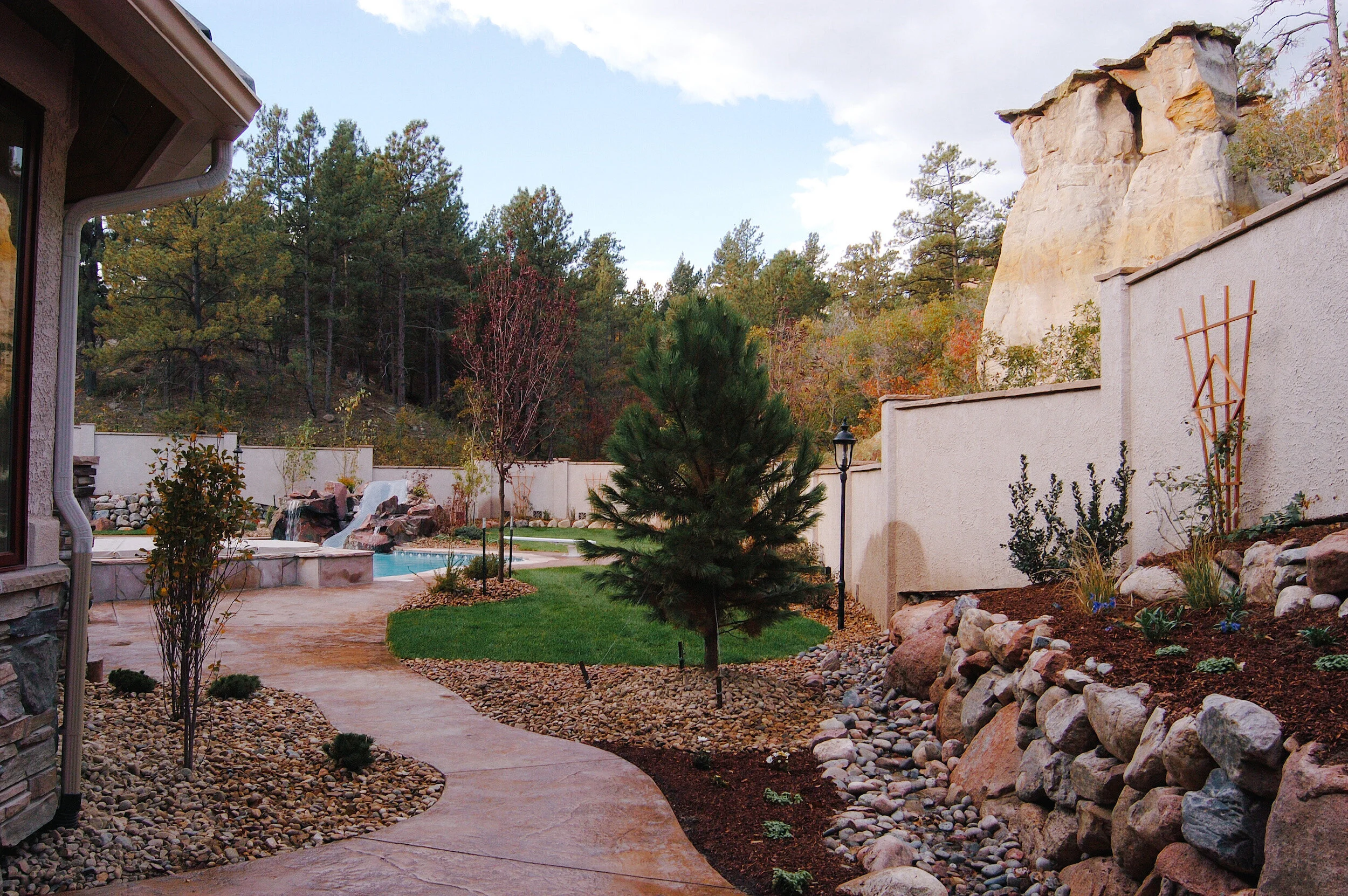 Colorado Springs custom home backyard with Colorado landscaping and trees.