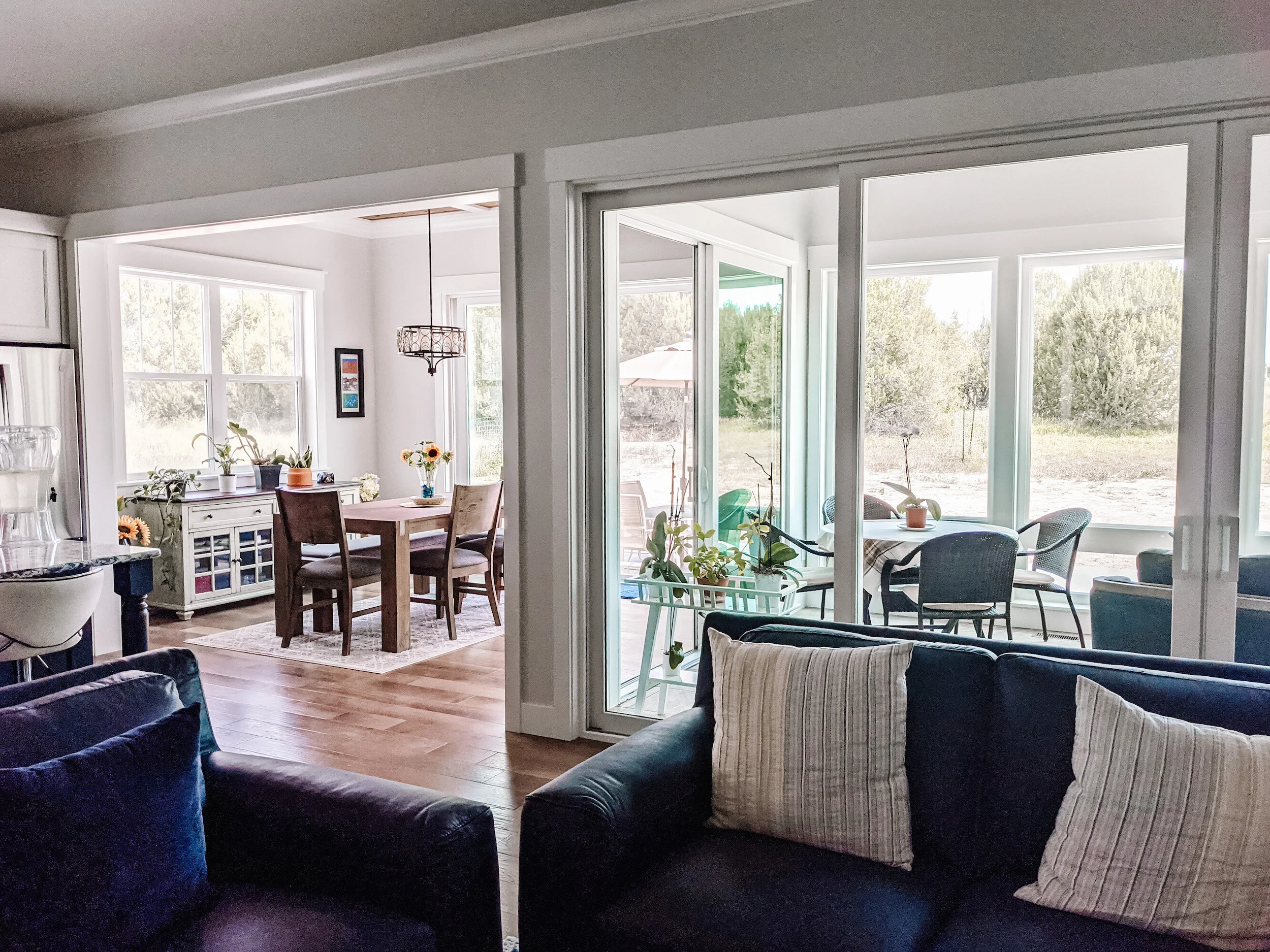Modern farmhouse interior with cozy dining room and enclosed sun room. 