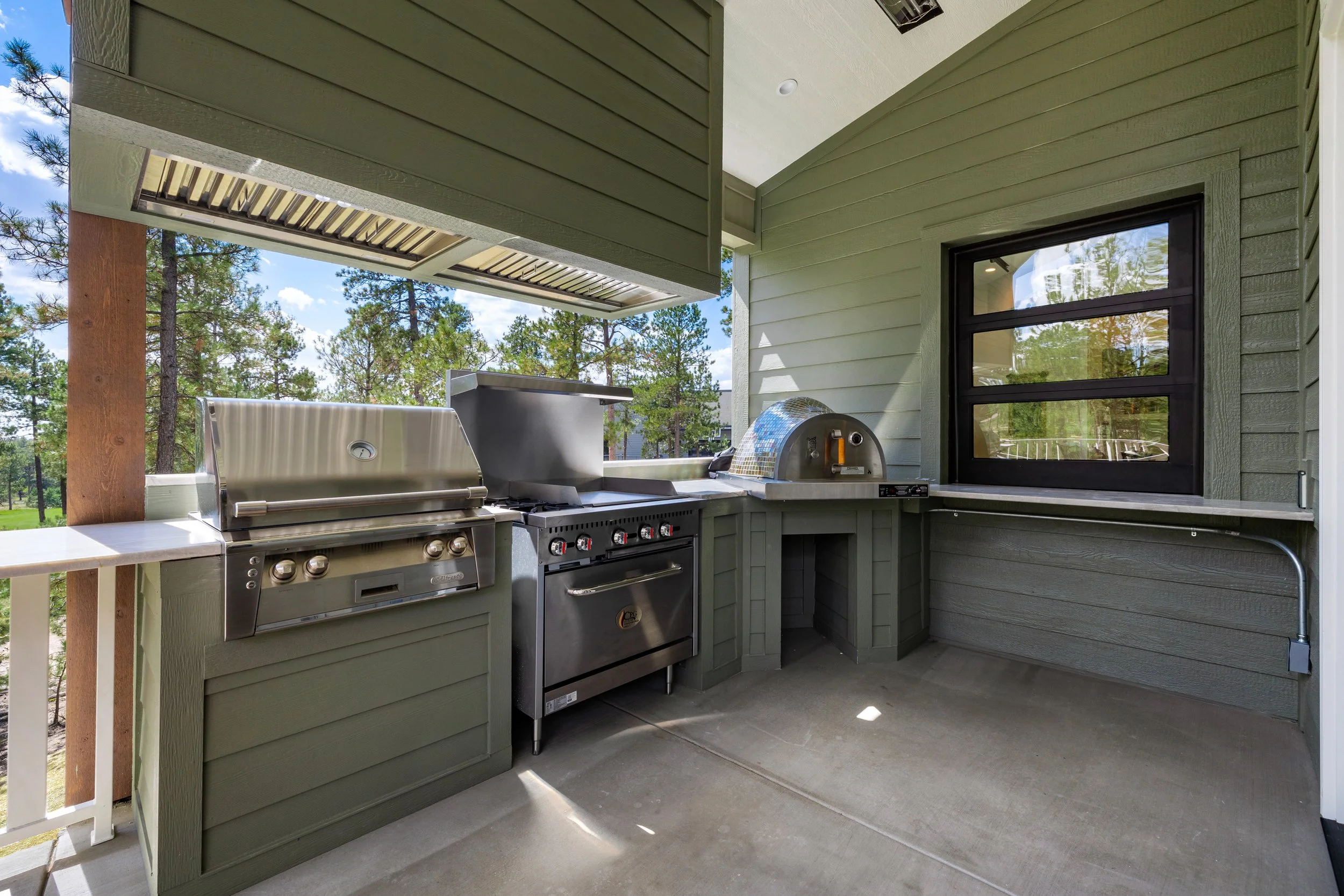Outdoor kitchen with pizza oven and grill.