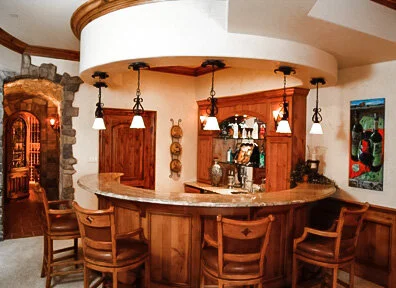 Curved European style bar and wine room in a Colorado custom home.