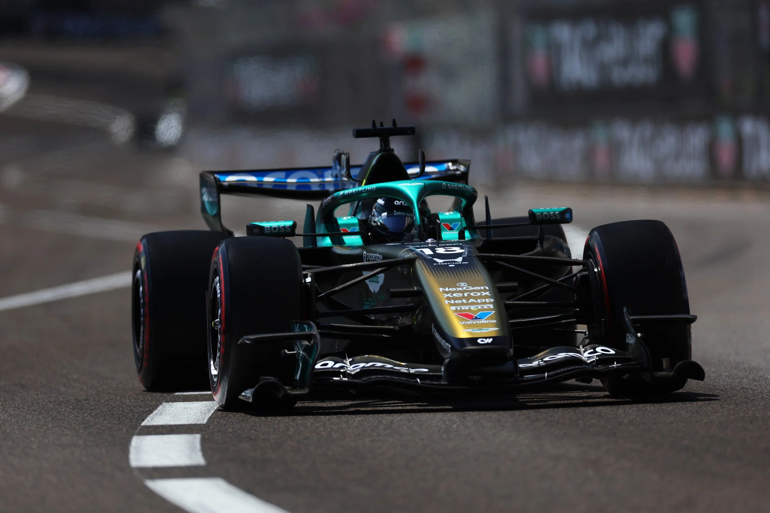 The special livery AMR26 Aston Martin Racing Formula 1 race car at Monaco with blurred background and tire barriers.