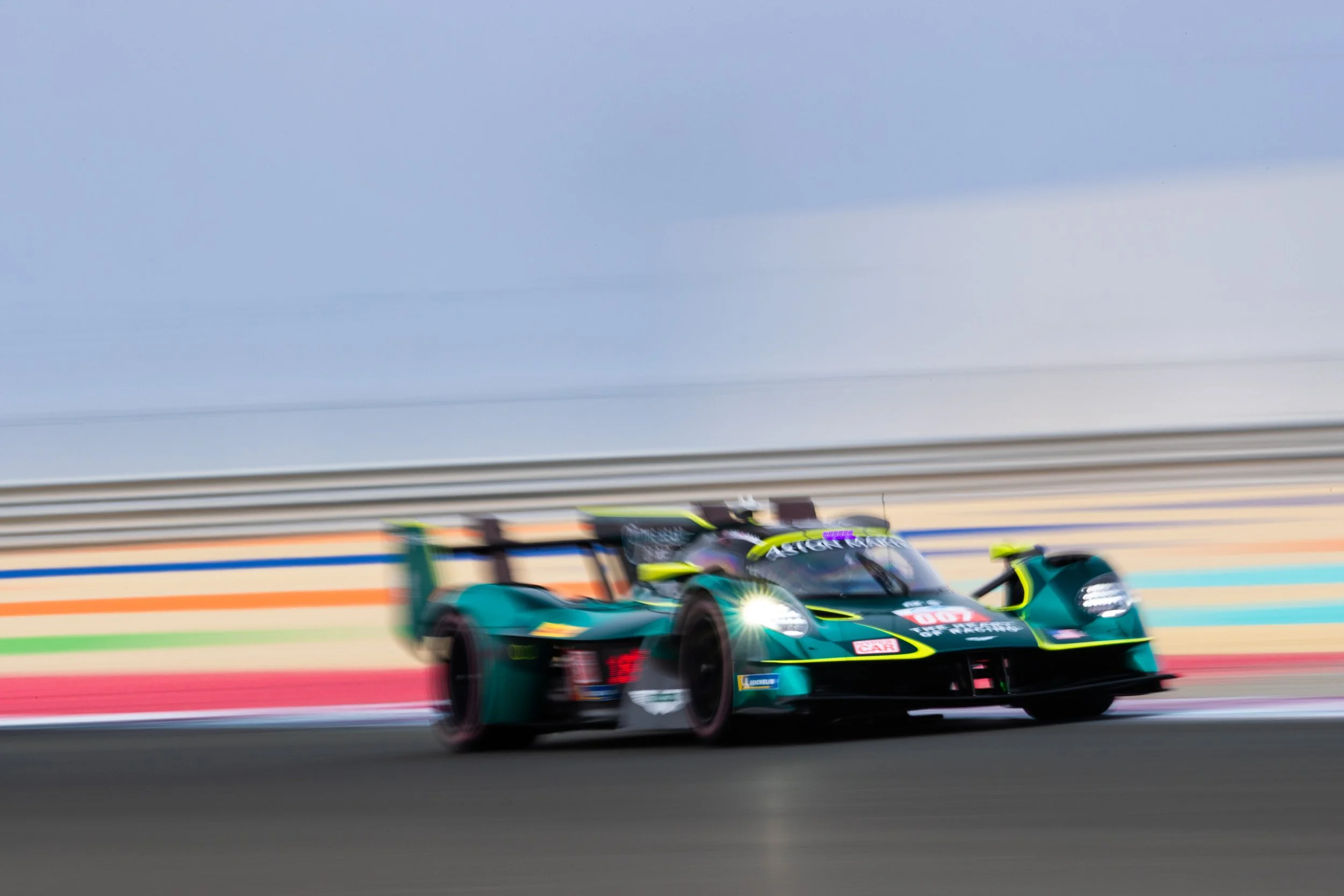 A race car speeding on a track with colorful racing lines, motion blur indicating high speed, and a blurred background.