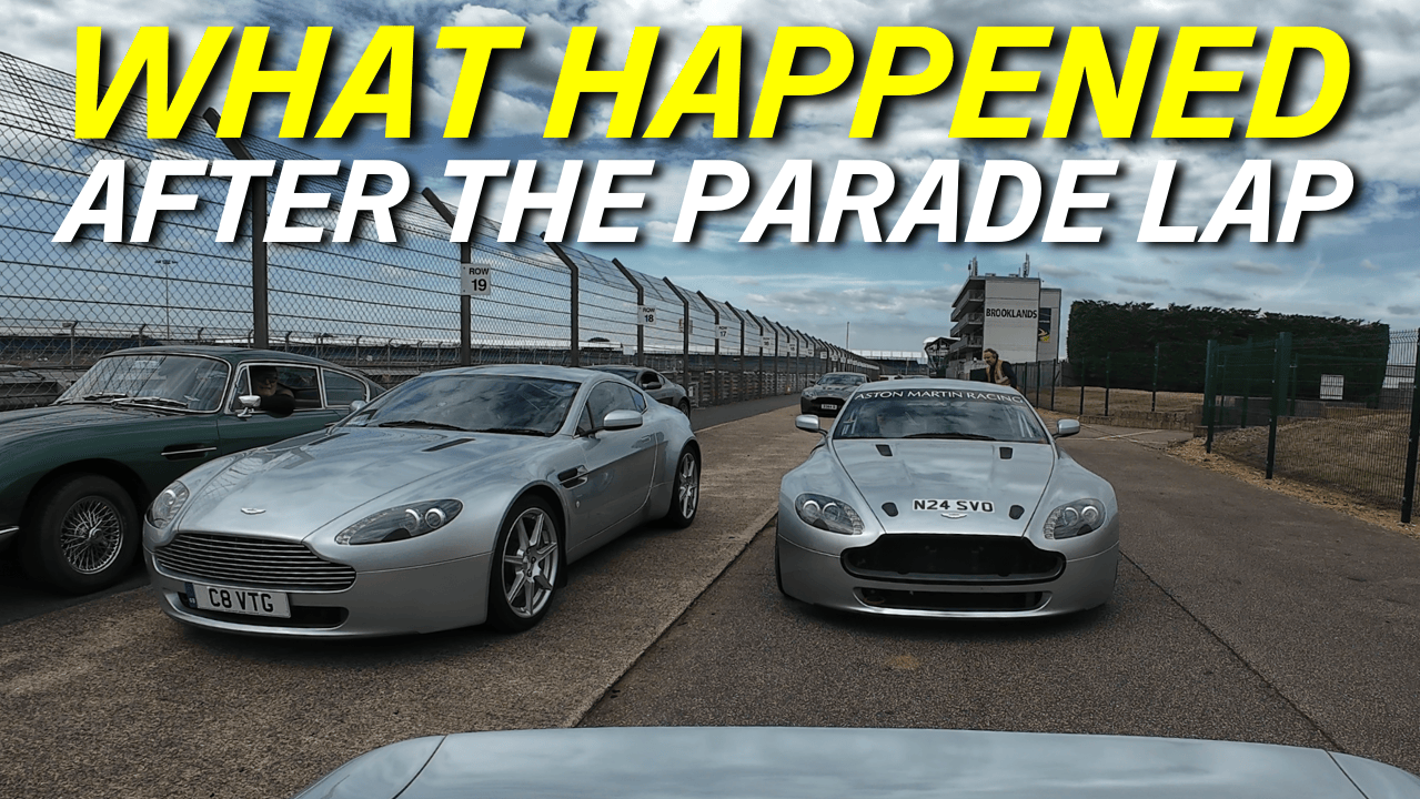 A collection of vintage and modern Aston Martin race cars parked beside Silverstone race track, with a cloudy sky overhead and a grandstand in the background. The image features bold yellow and white text over the scene.