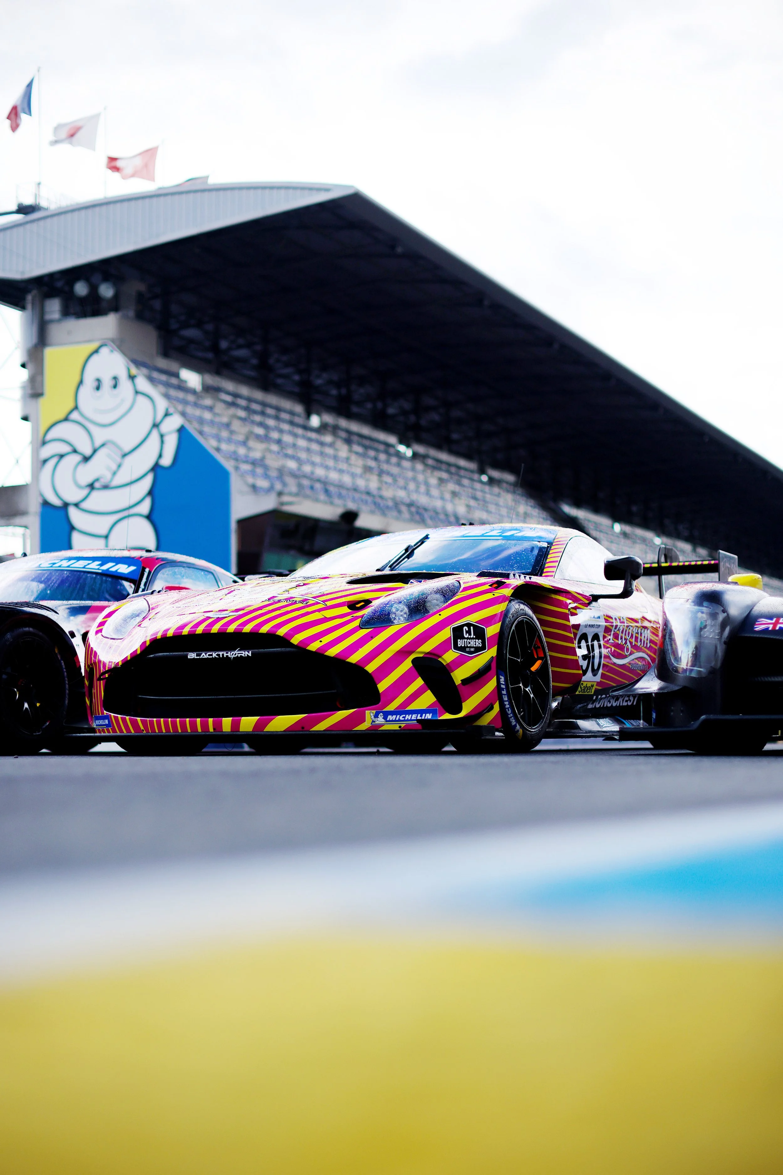 Blackthorn Racing Aston Martin Vantage GT3 on a track with a large Michelin logo and a grandstand in the background.