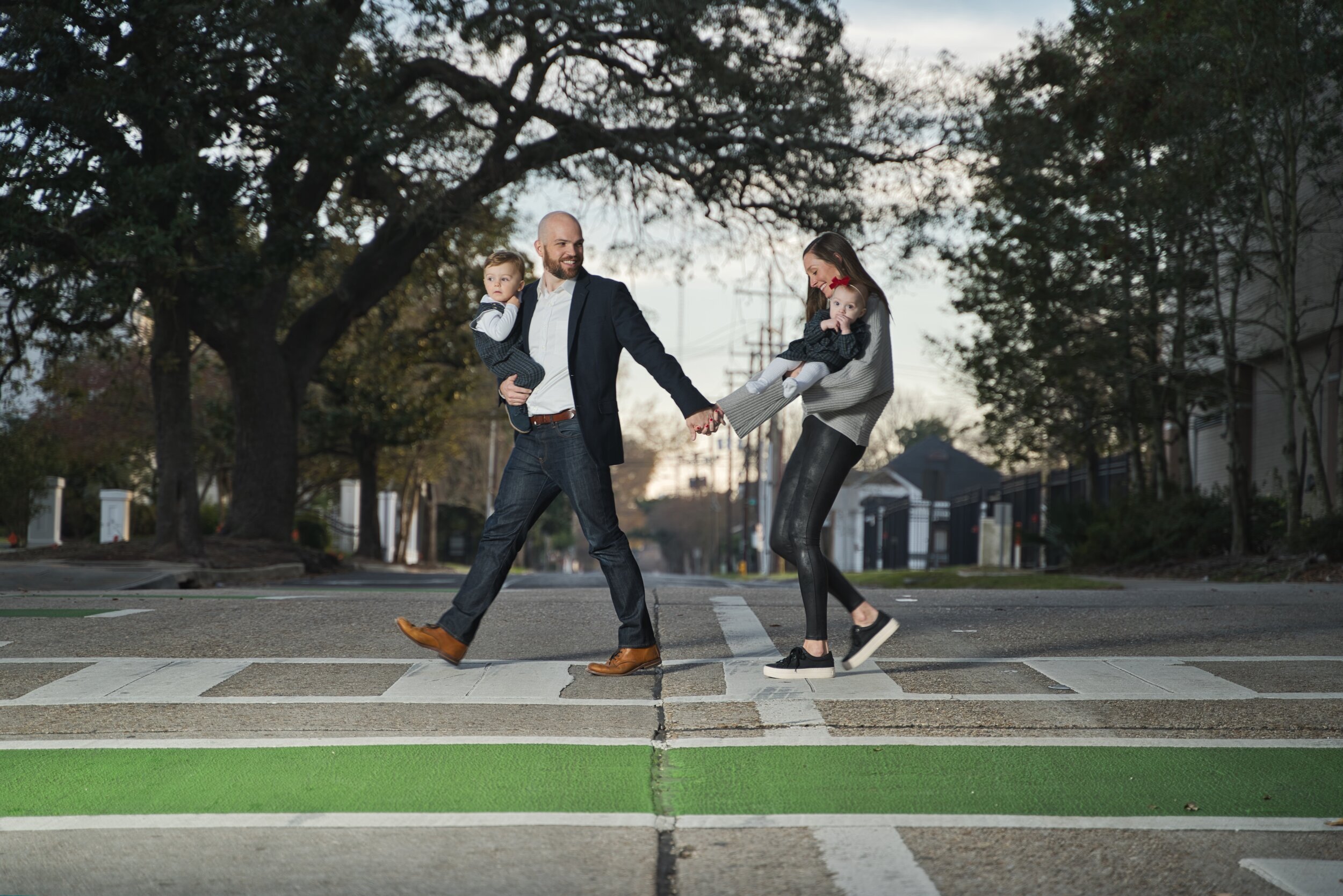 Family with two children walking across a crosswalk holding hands