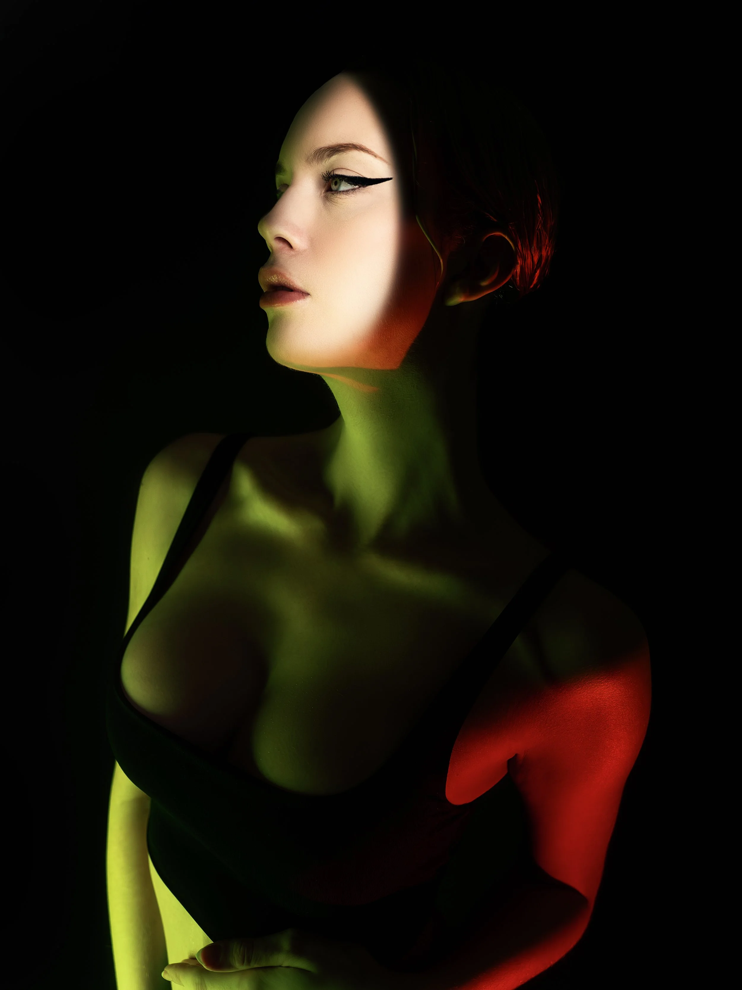 Portrait with dramatic colored light and sculptural shadows