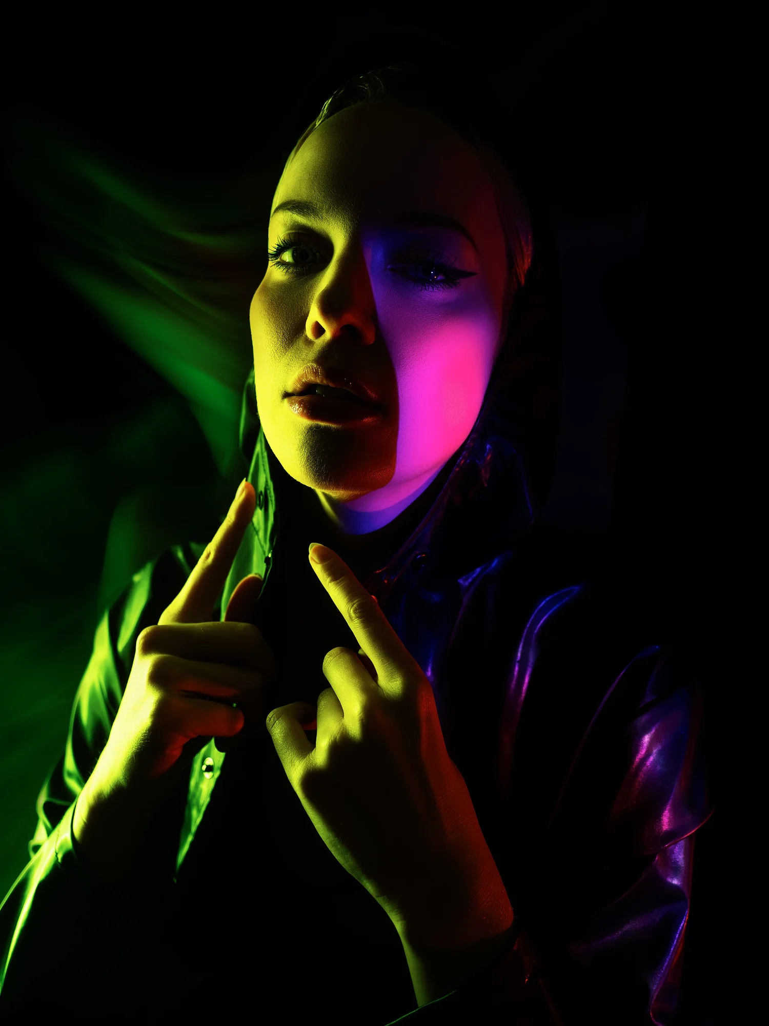 Expressive portrait illuminated by vivid green and purple lighting