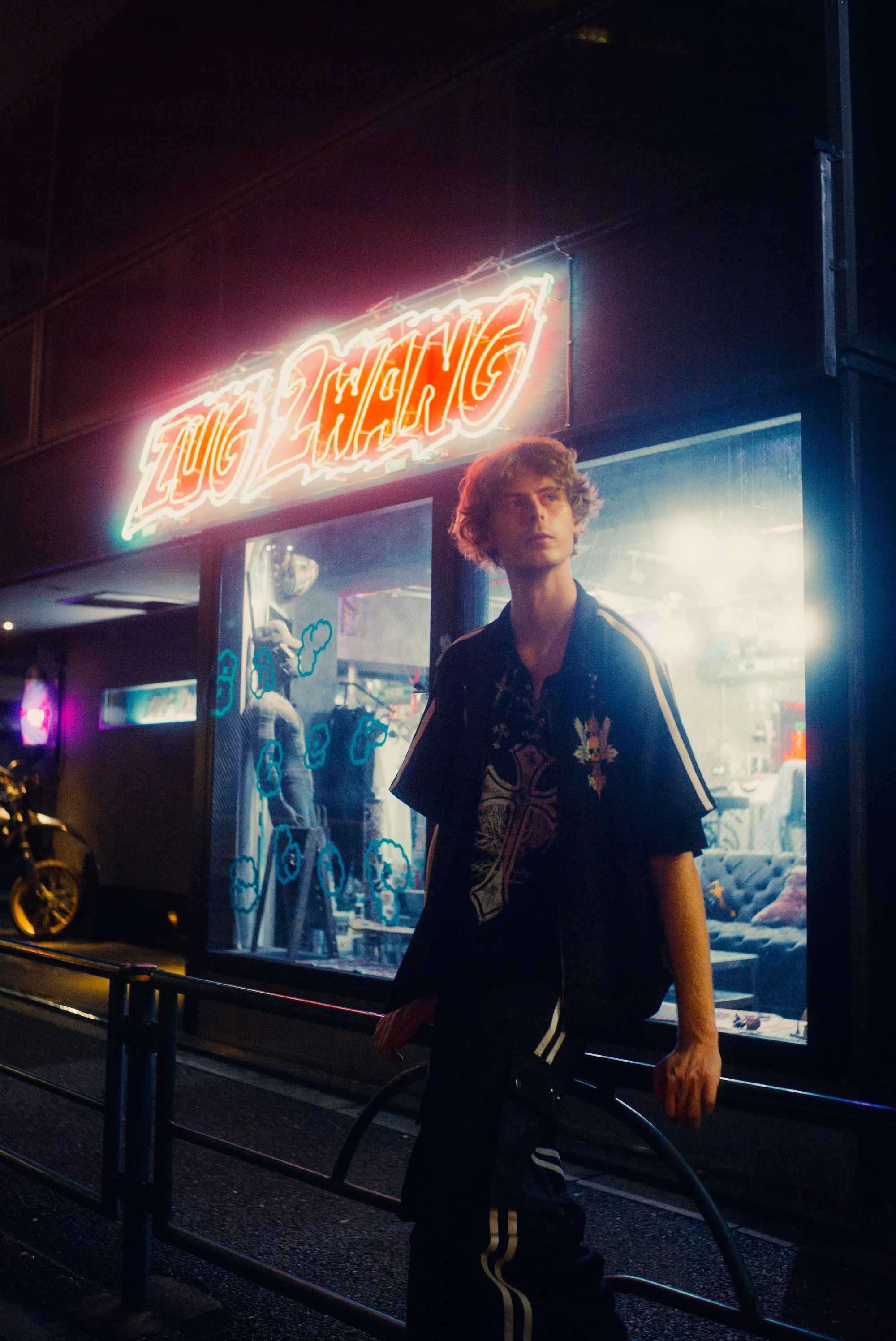 Cinematic night portrait beneath glowing signs during a creative Tokyo photoshoot