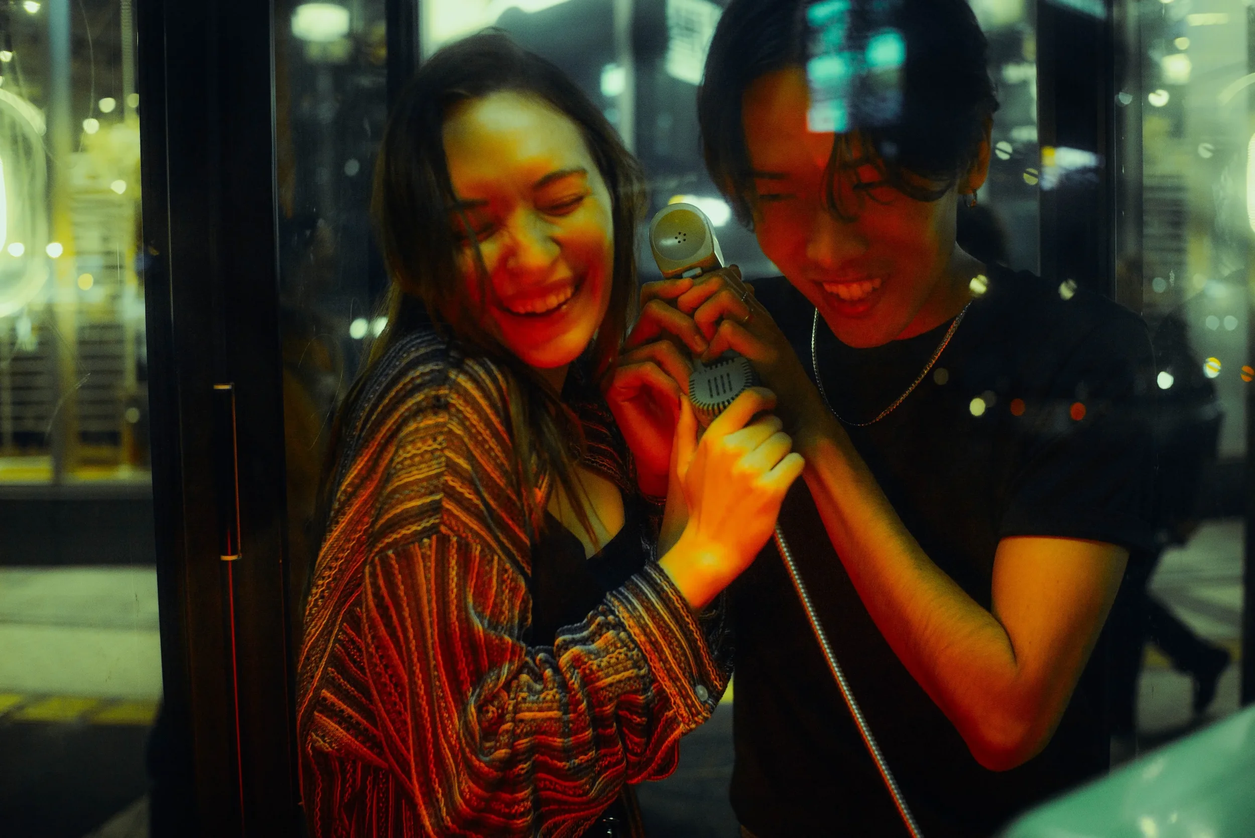 Couple sharing a candid moment during a nighttime photoshoot in Tokyo