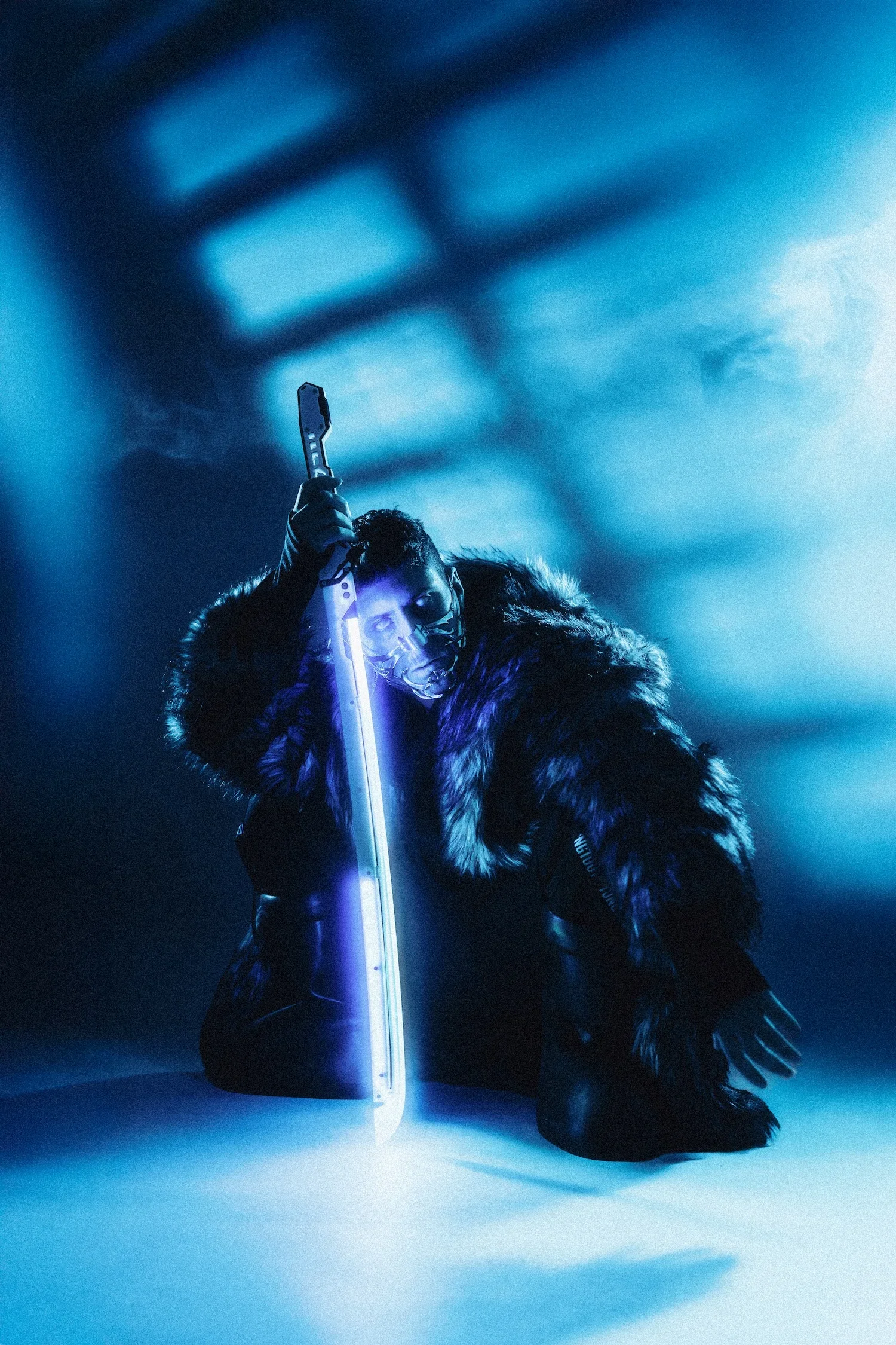 A person dressed in dark clothing with a fur coat, holding a glowing sword, illuminated by blue lighting, with a dark and abstract background.