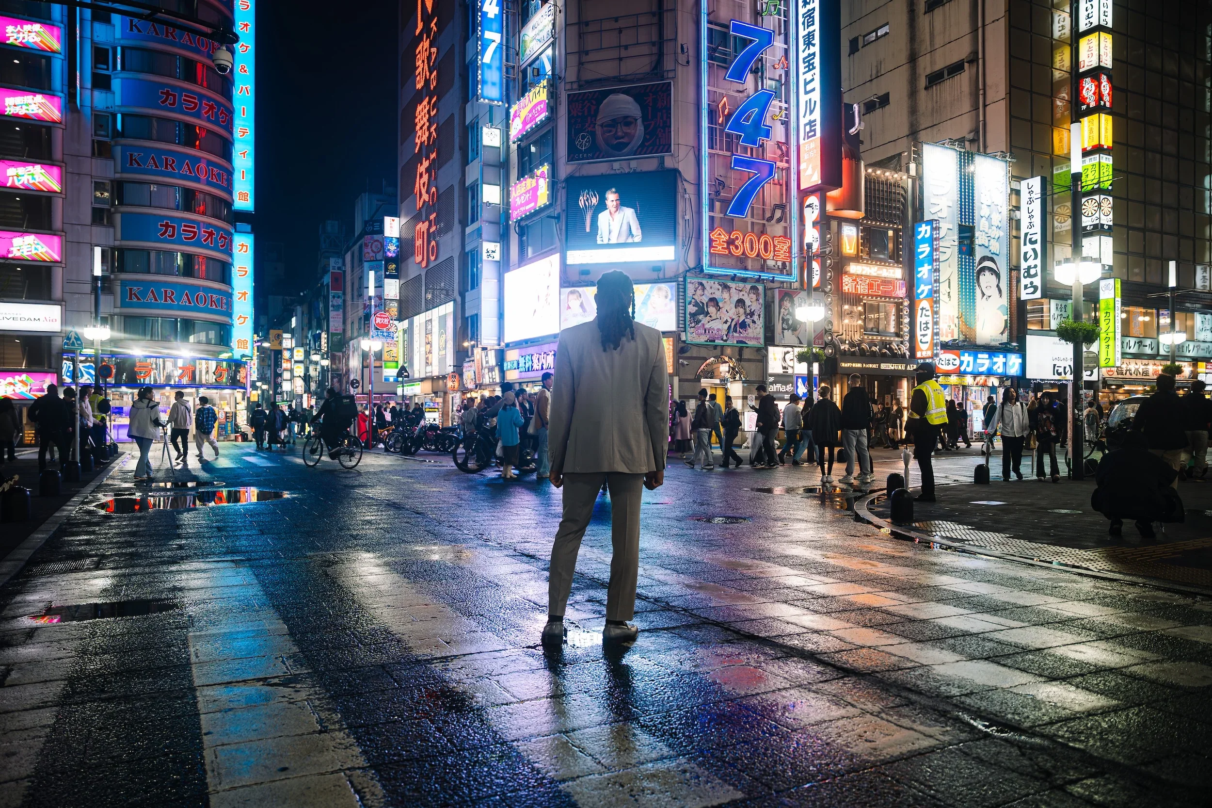 Man in a suit photographed against the bright city lights of Shibuya during a Tokyo portrait photoshoot