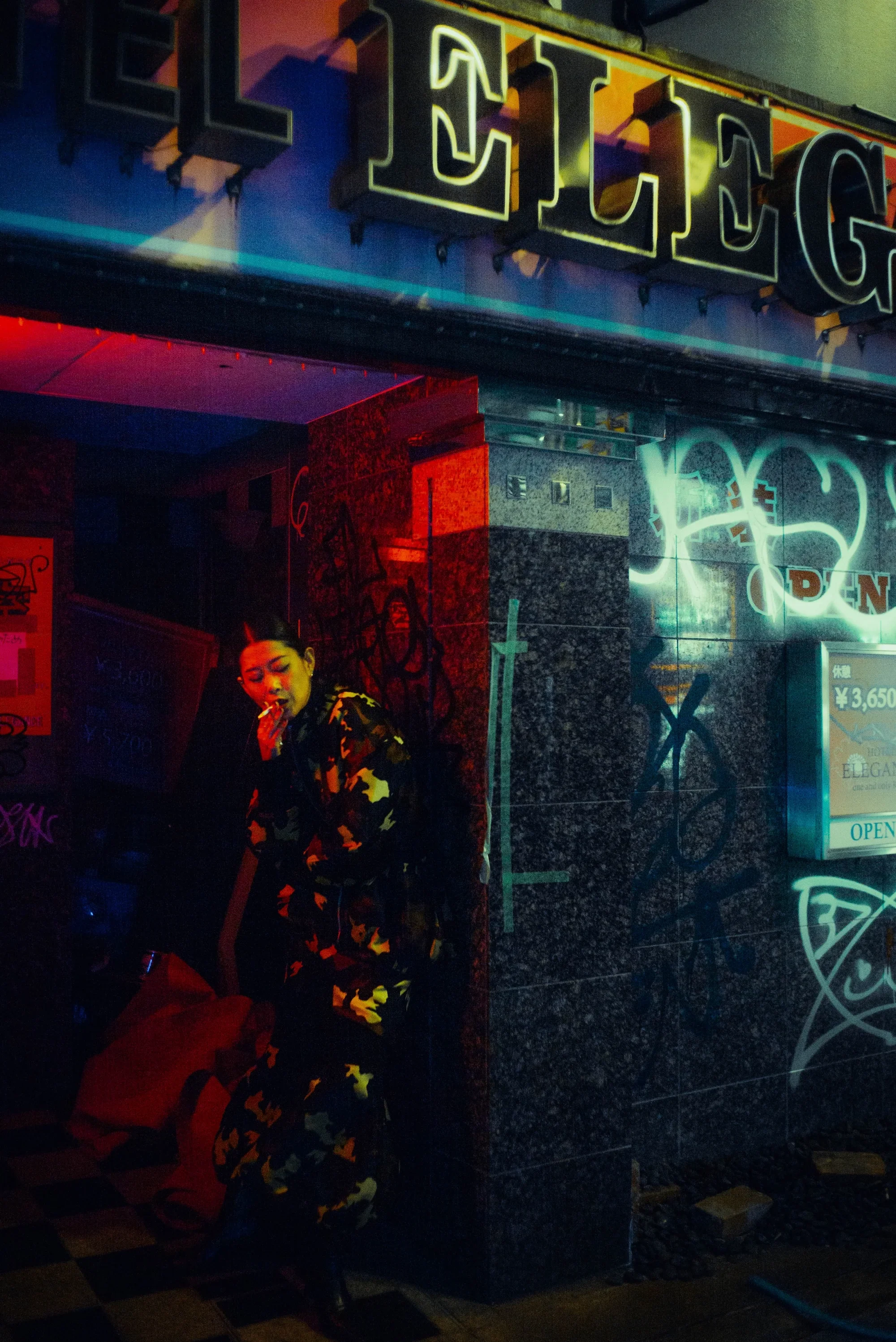 Moody street portrait against a graffiti-covered wall during a Tokyo night photoshoot