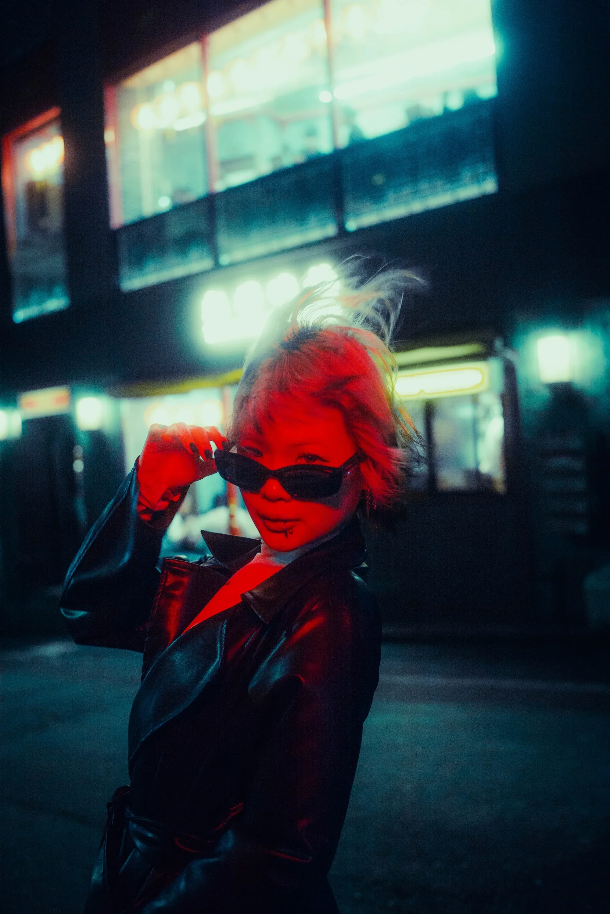 Creative street portrait with dramatic red lighting during a Tokyo After Dark photoshoot