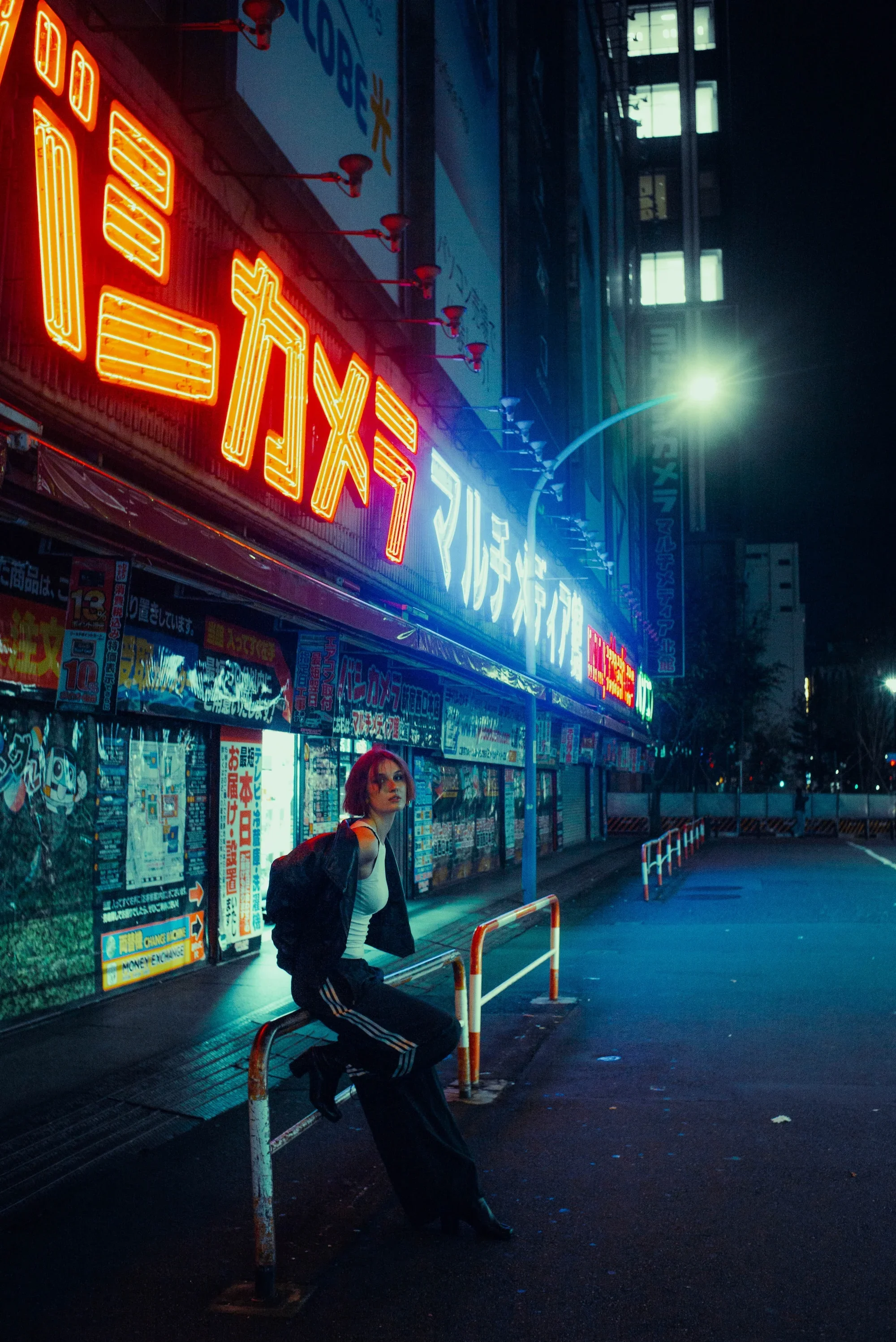 Cinematic street portrait beneath colorful Japanese signs during a Tokyo night photoshoot in Shinjuku