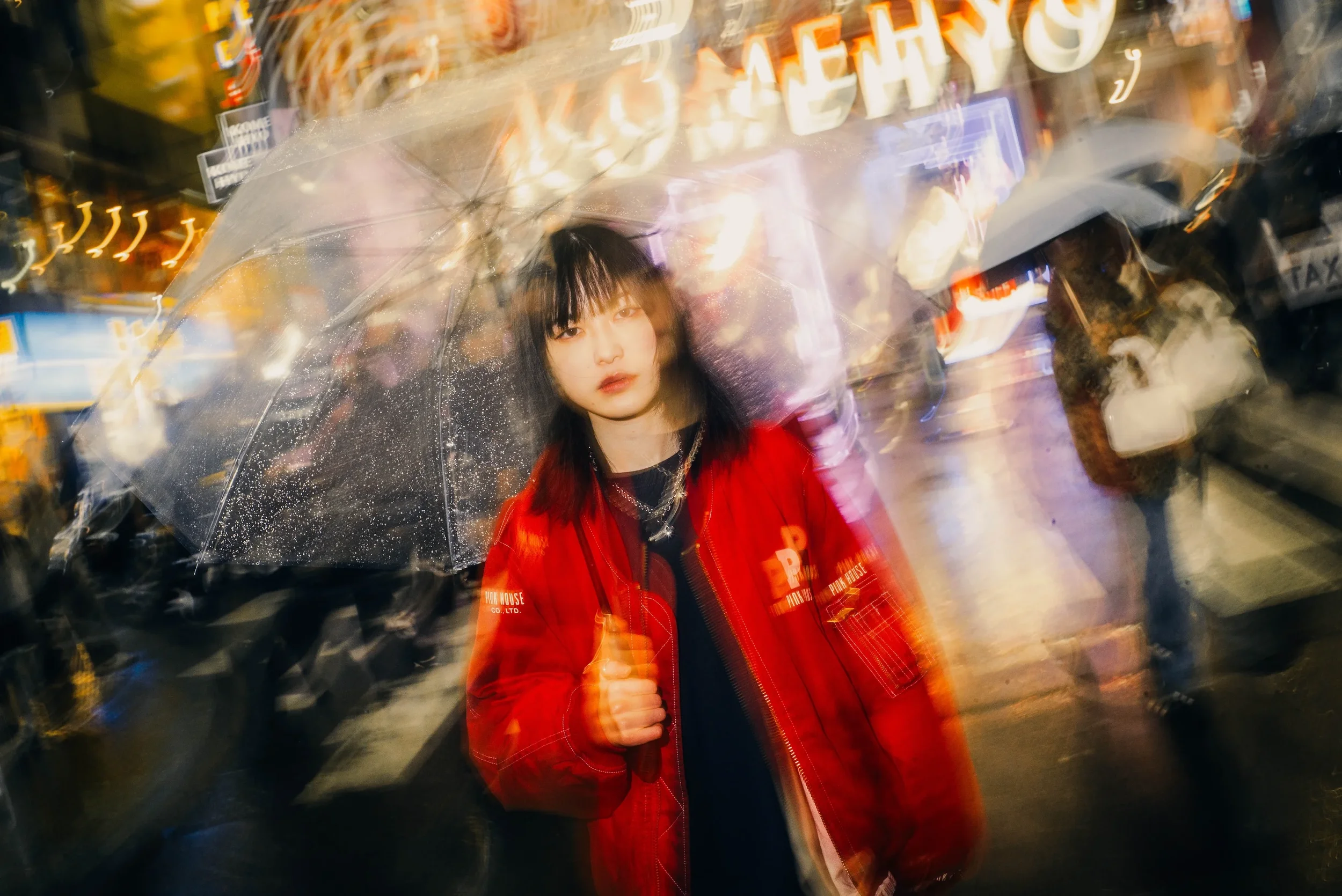 Portrait under an umbrella with motion blur during a creative Tokyo night photoshoot