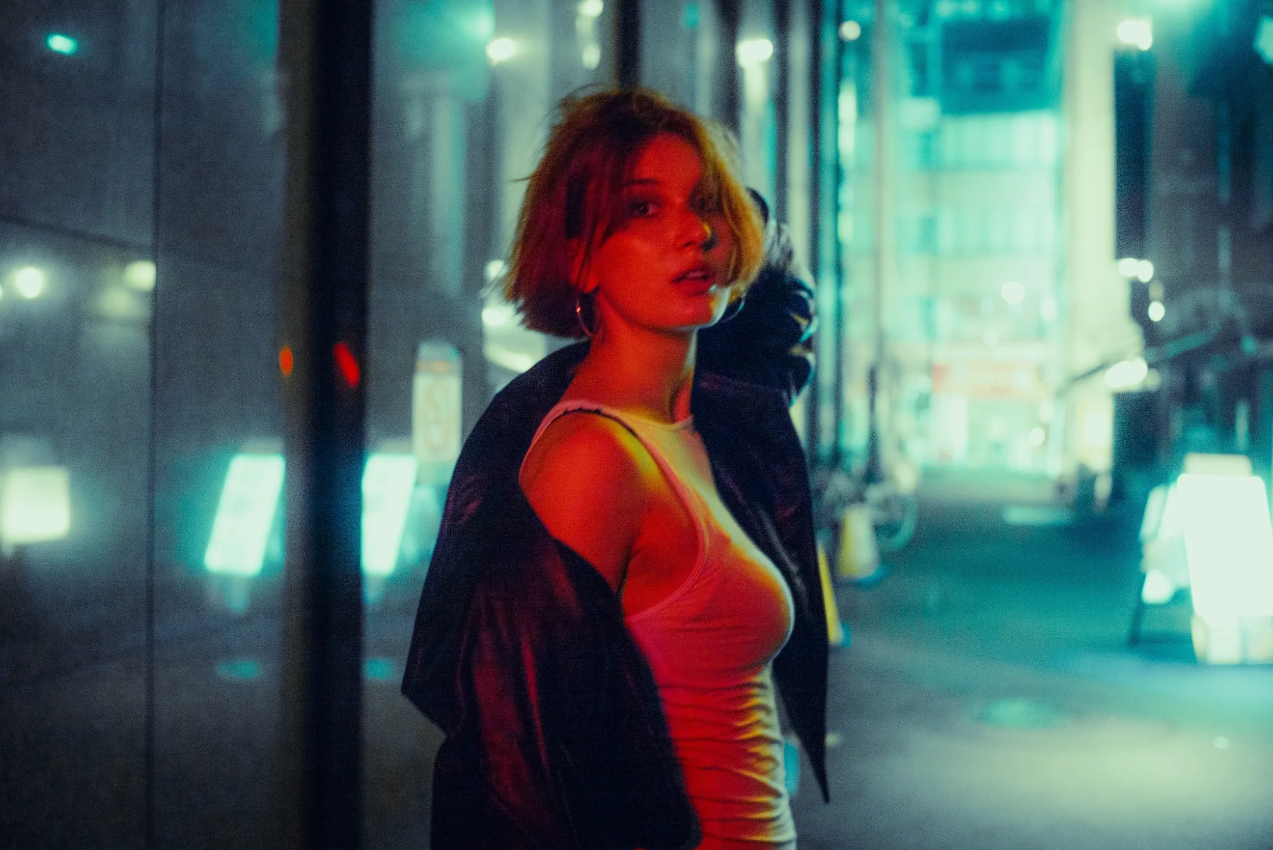 Cinematic solo portrait illuminated by colorful Tokyo city lights during a night photoshoot