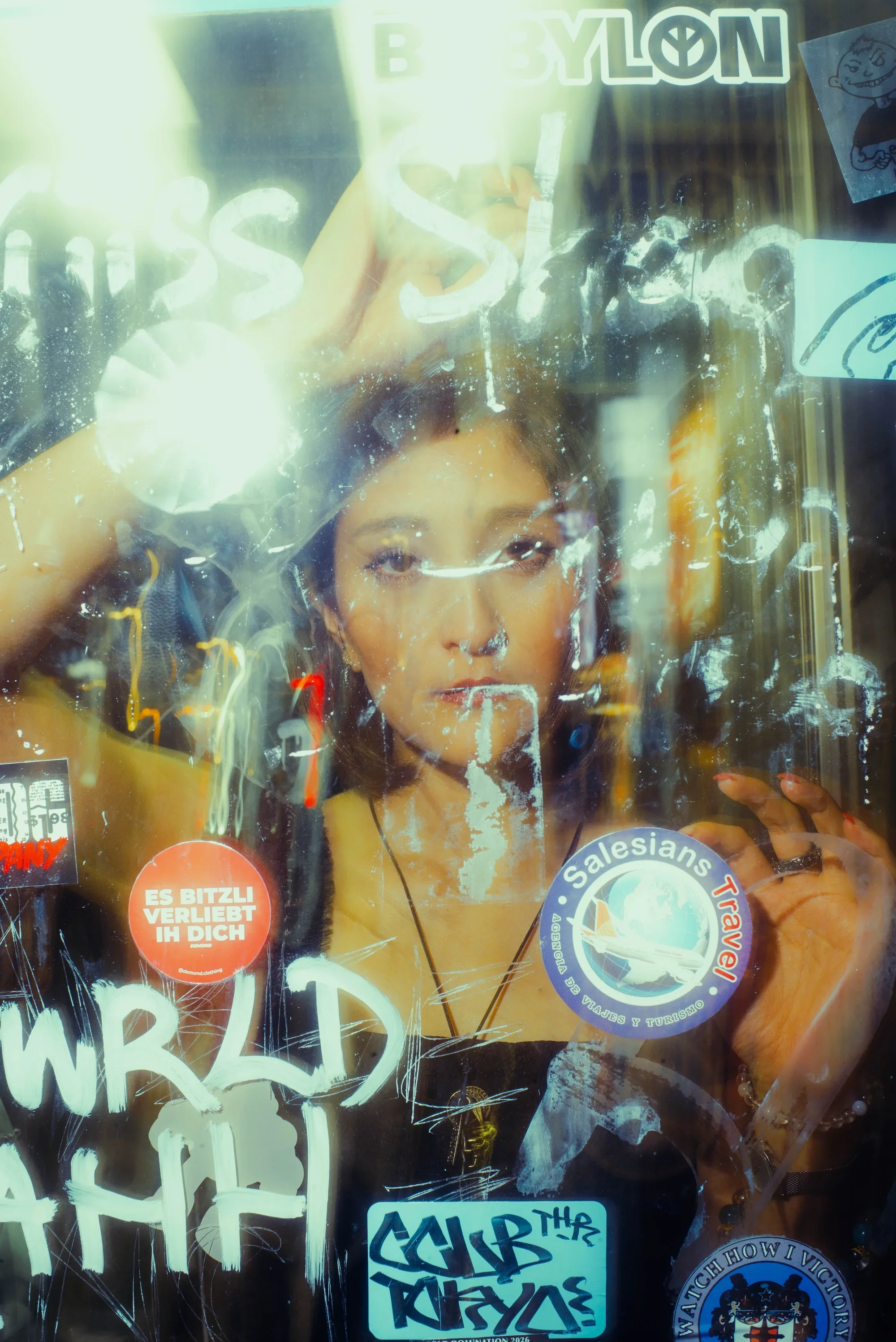 Solo portrait photographed through a reflective window during a creative Tokyo night photoshoot