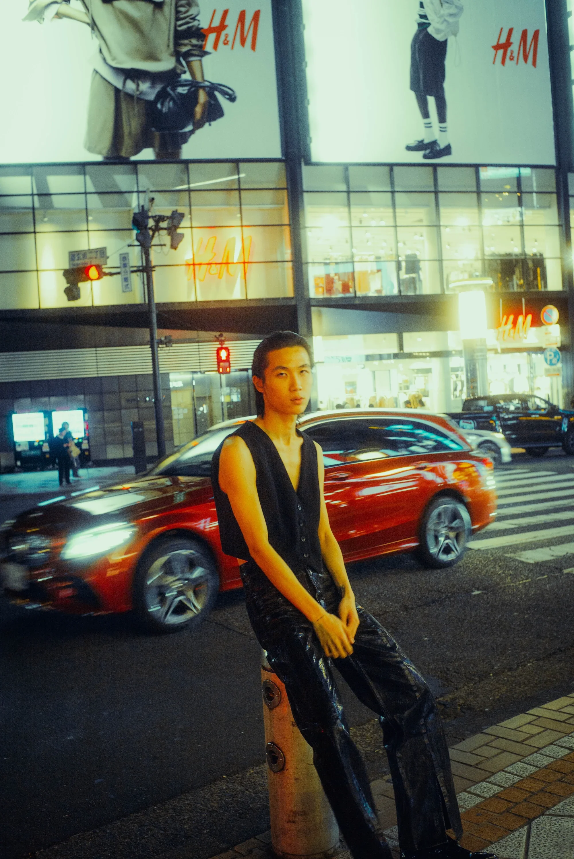 Solo portrait on a busy Tokyo street with passing traffic and city lights