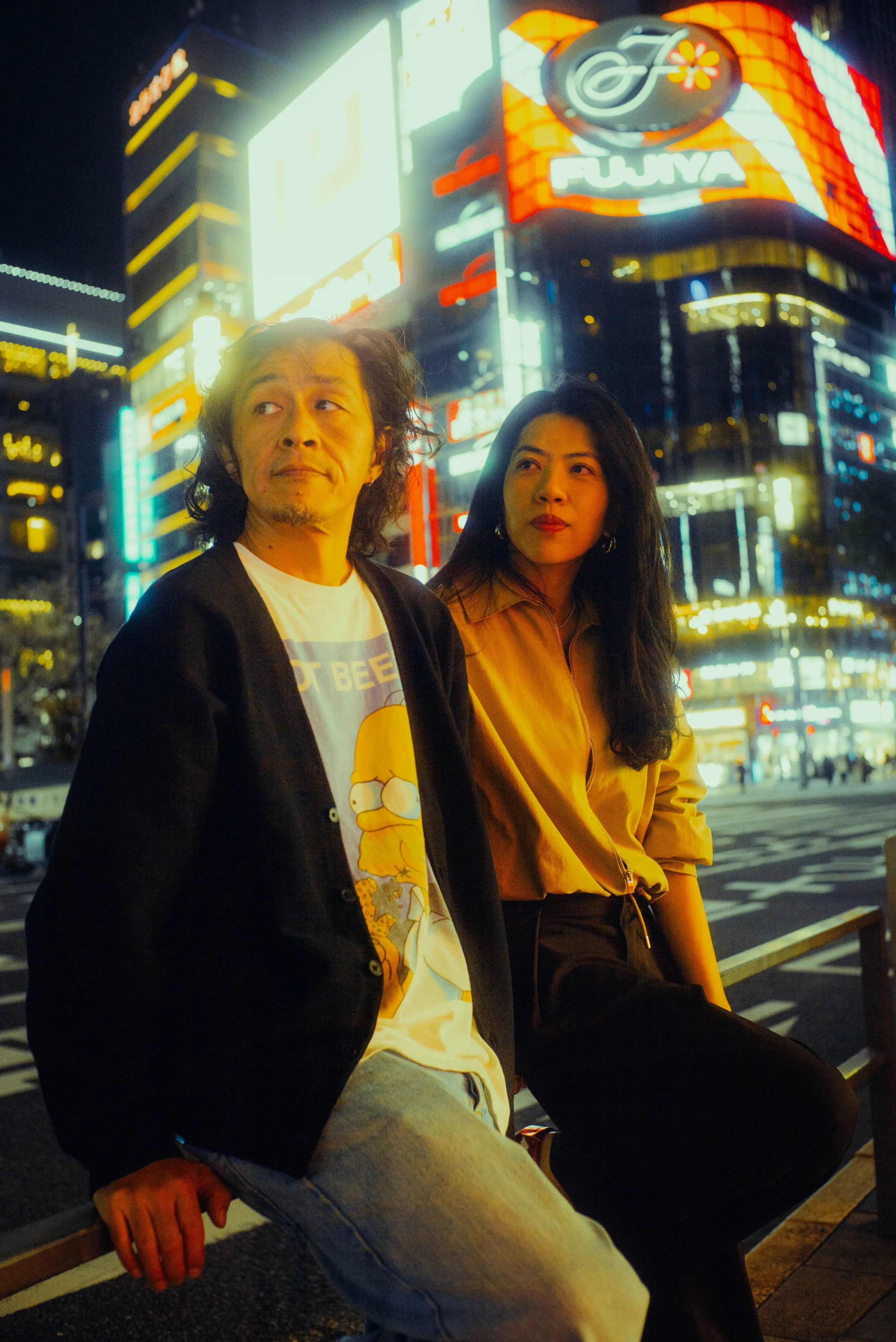 Couple portrait surrounded by colorful Tokyo nightlife and illuminated signs