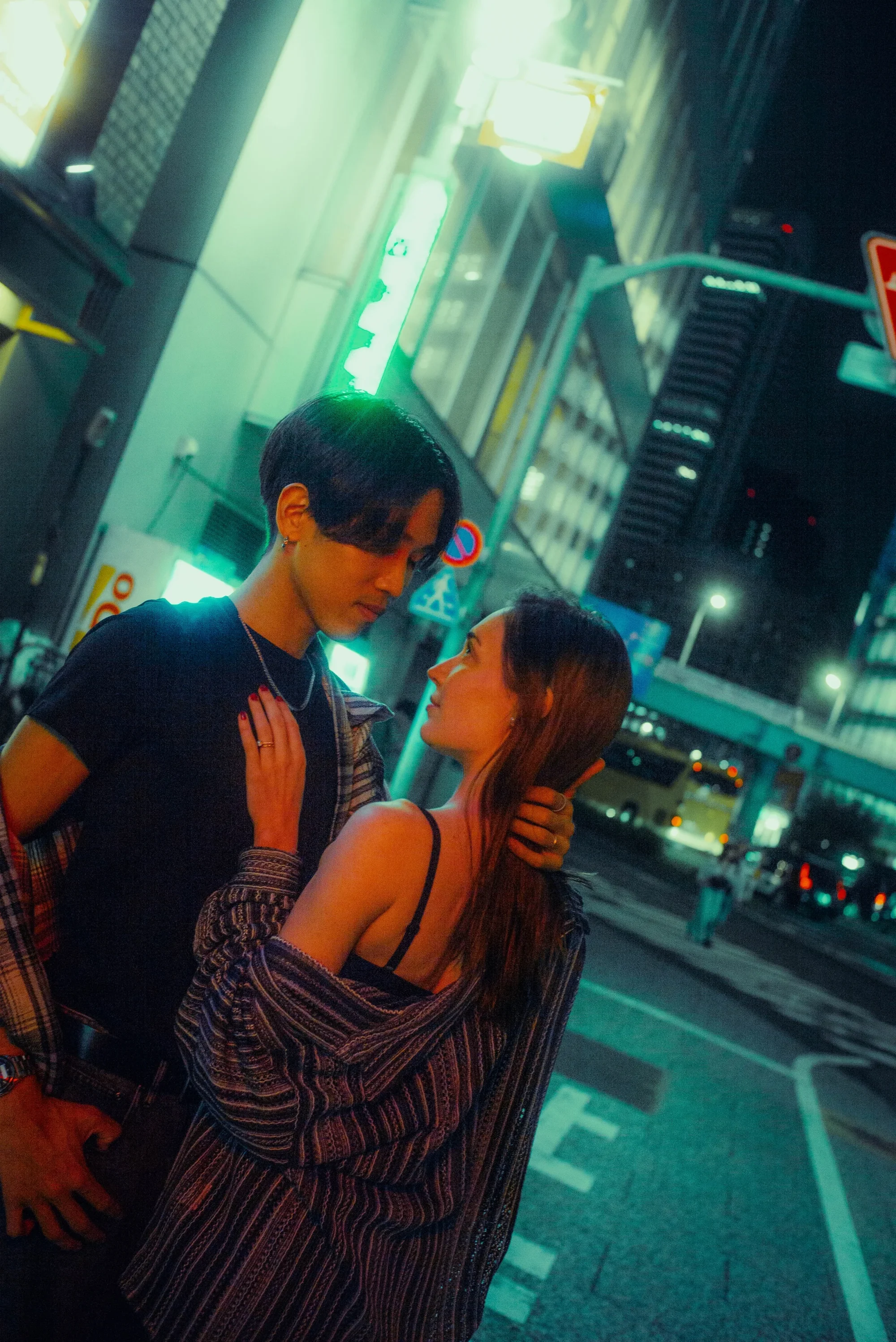 Couple posing together under city lights during a nighttime Tokyo photoshoot