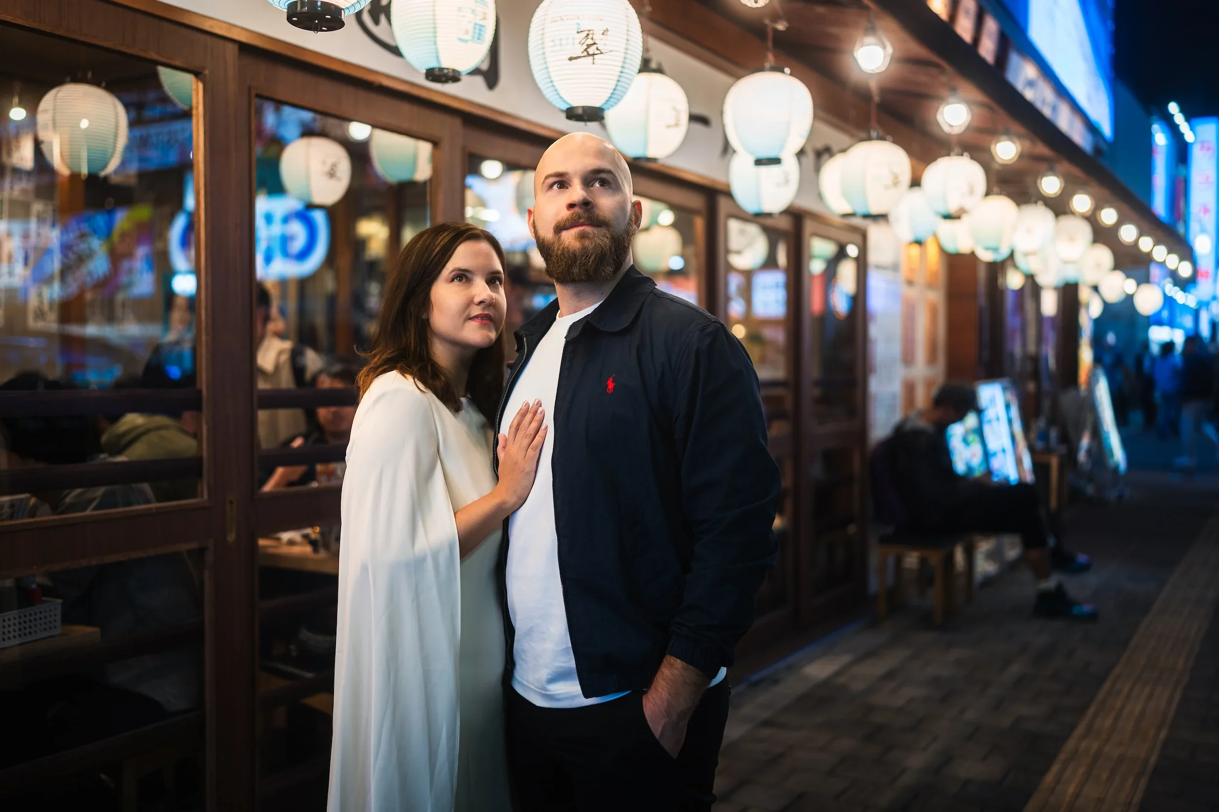 Couple posing beneath Japanese lanterns during a professional Tokyo night photoshoot