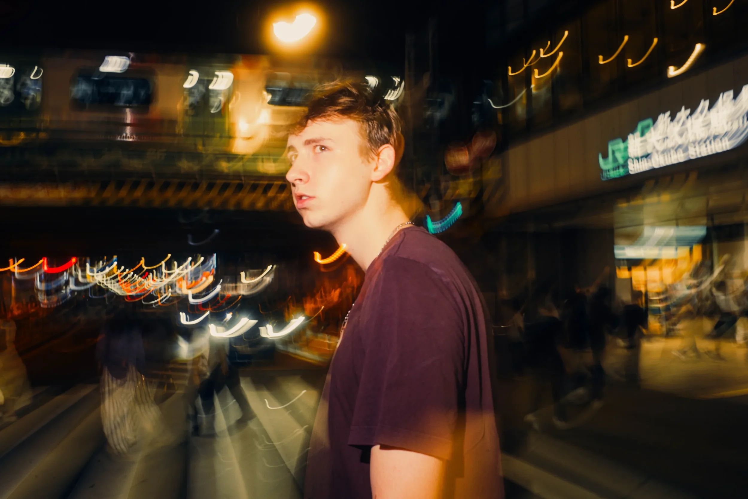 Creative street portrait with motion-blurred Tokyo nightlife and city lights