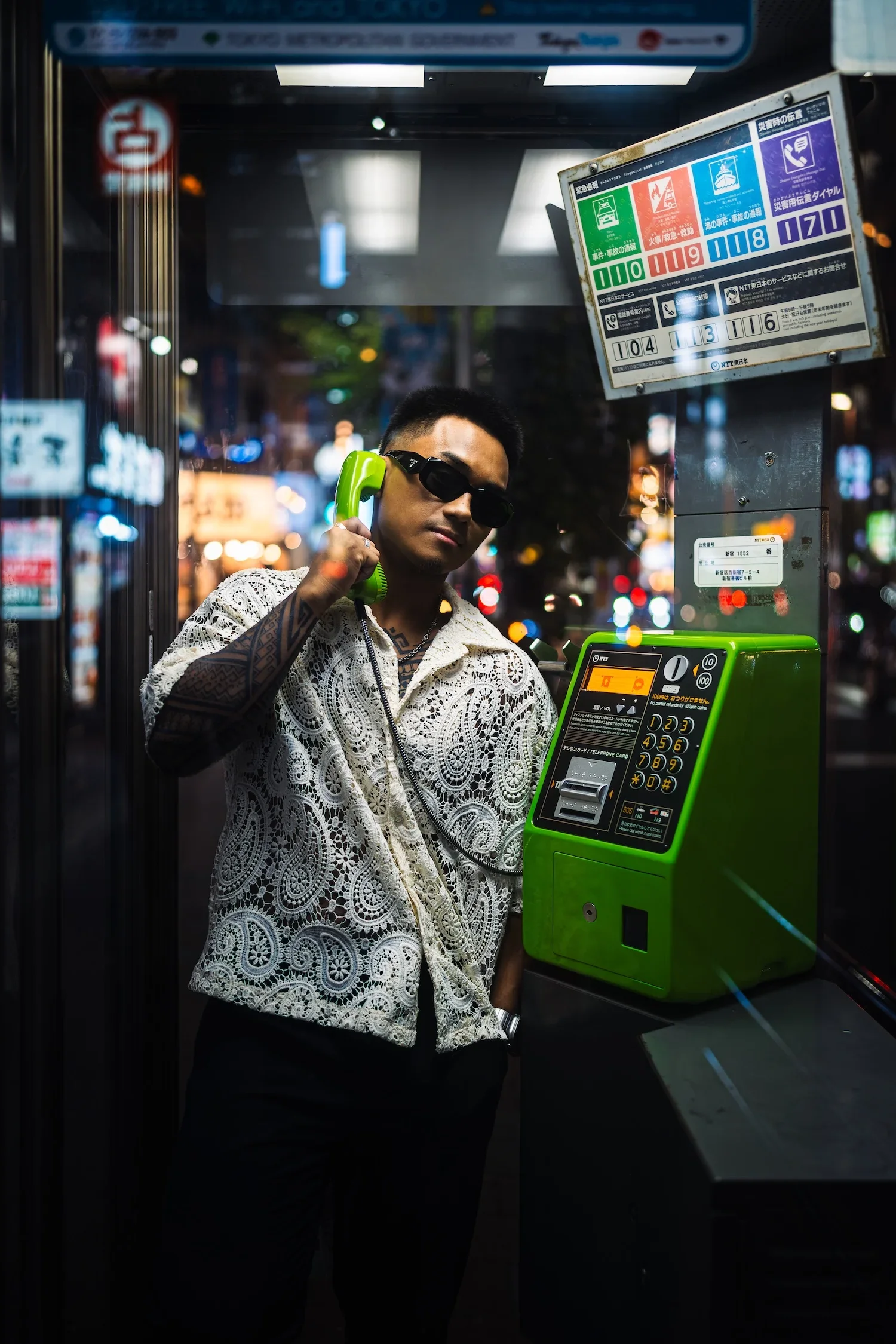Man posing beside colorful signs in Shibuya during a Tokyo street style photoshoot