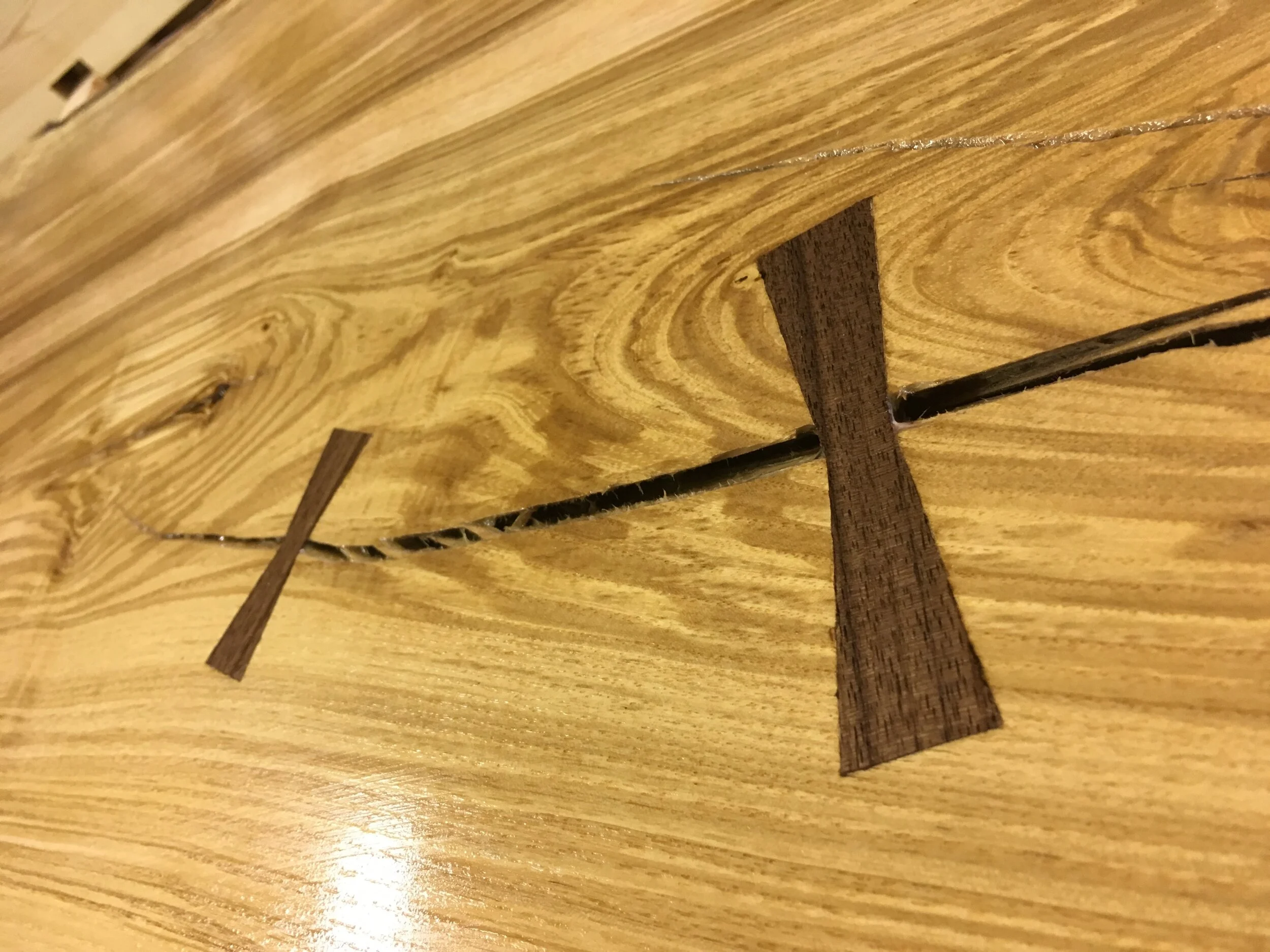Close-up of a wooden surface with small wooden pieces and a slit in the wood.