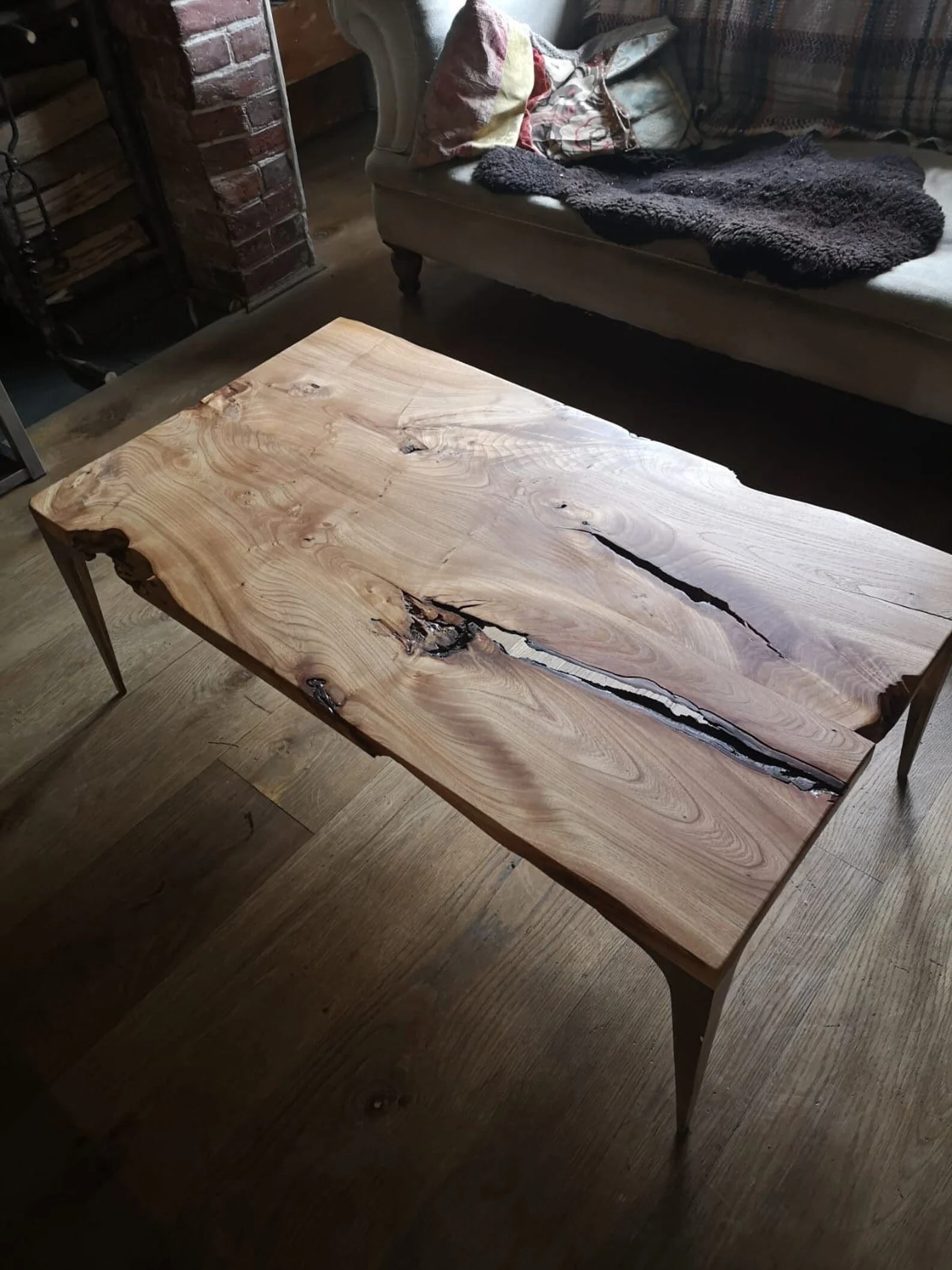 A wooden coffee table with a natural live edge and unique grain pattern in a living room setting.