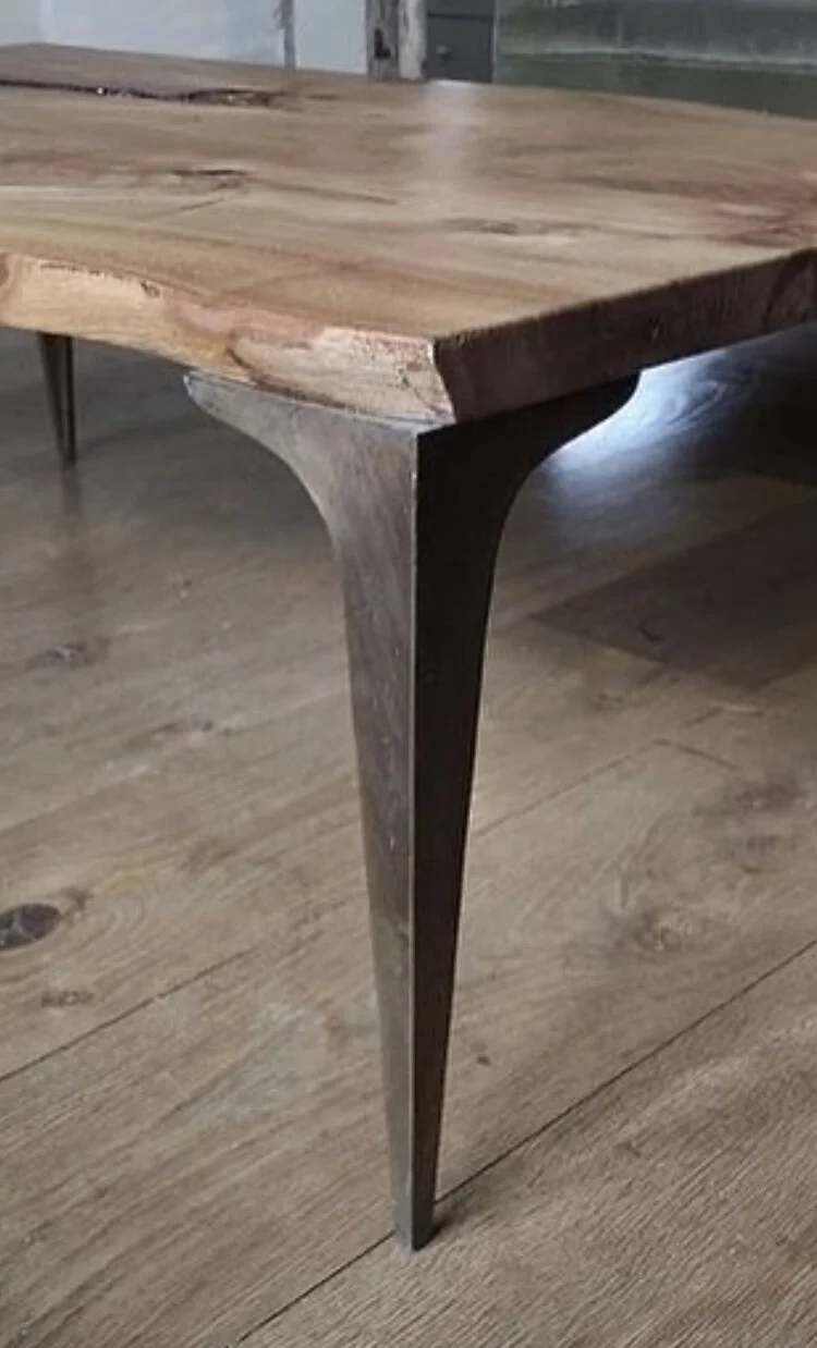 Close-up of a wooden table with metal legs on a hardwood floor.