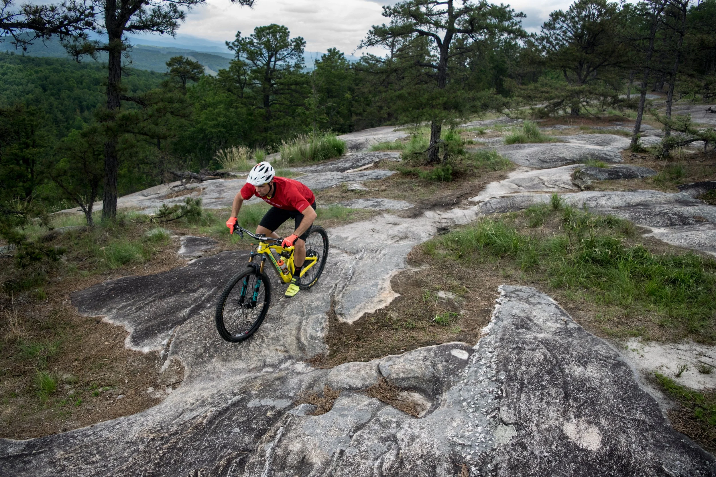 A mountain bike rider rides across bare rock slab during aMountain Biking Lesson in Dupont on Big Rock Trail