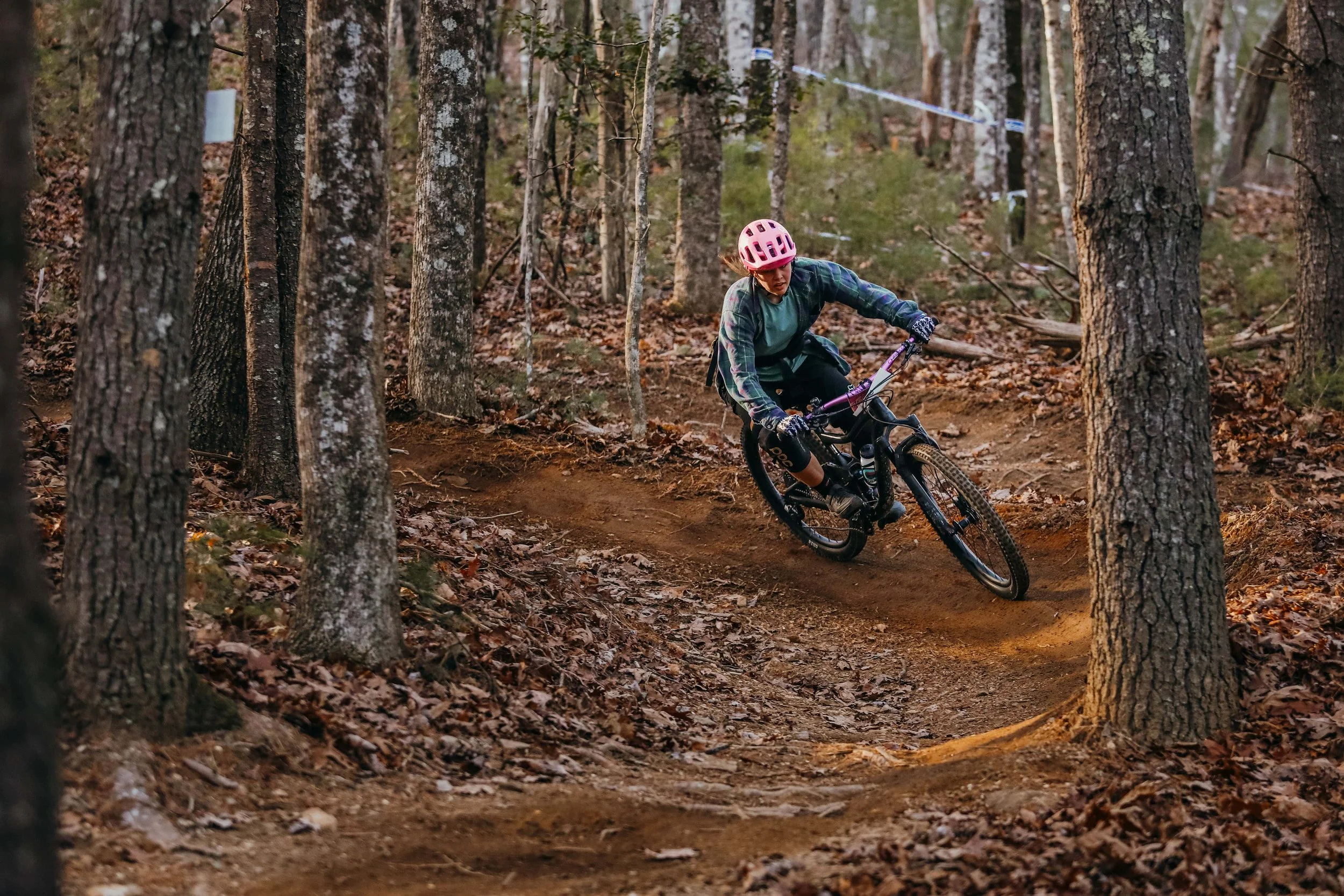 A mountain biker rides a dirt corner in Pisgah National Forest