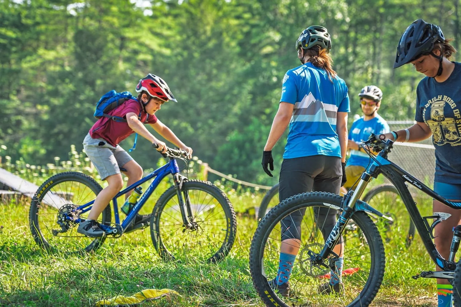 Image of a youth rider in a grass field during a youth skills mountain bike camp