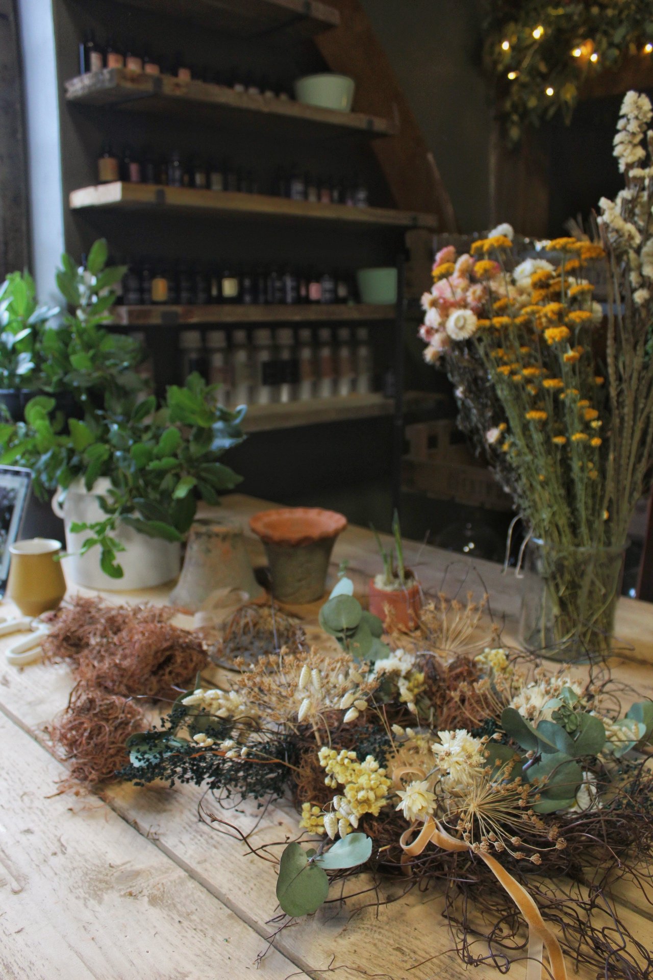 Seasonal flowers and dried materials arranged on the studio worktable