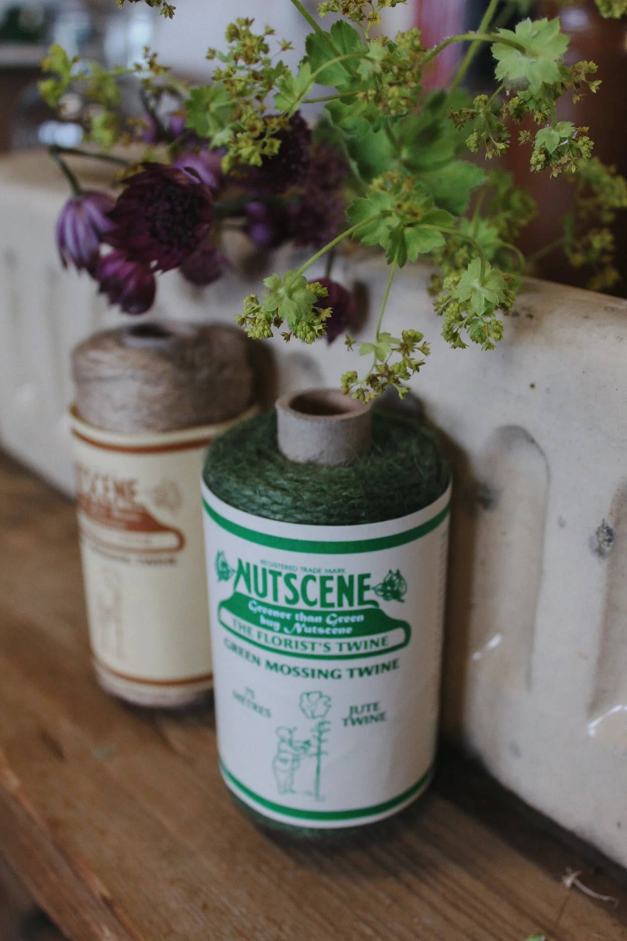 Florist mossing jute twine beside garden flowers
