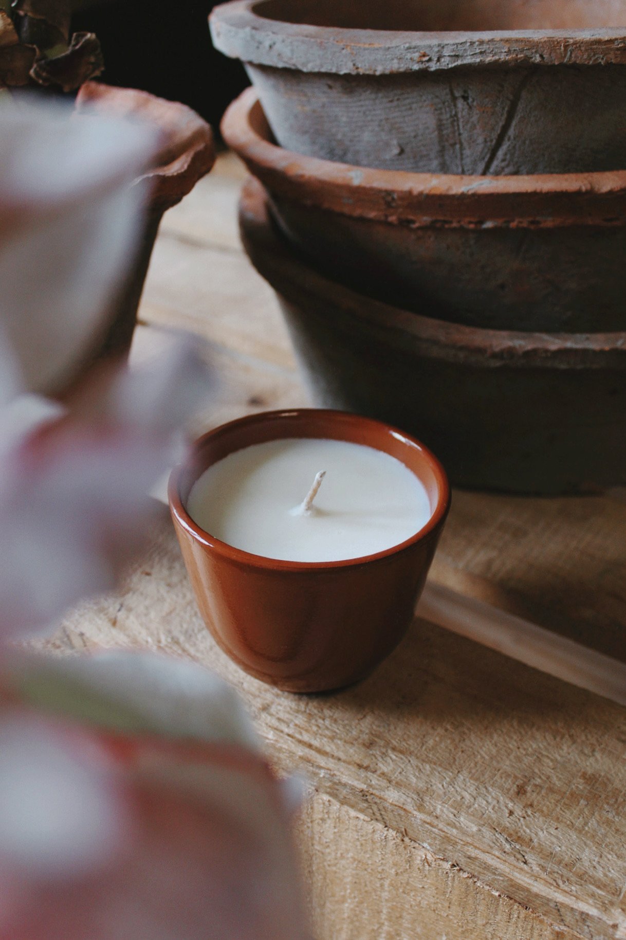 Glazed terracotta Herb Bed candle with a fresh green herbal blend, photographed in the potager studio.